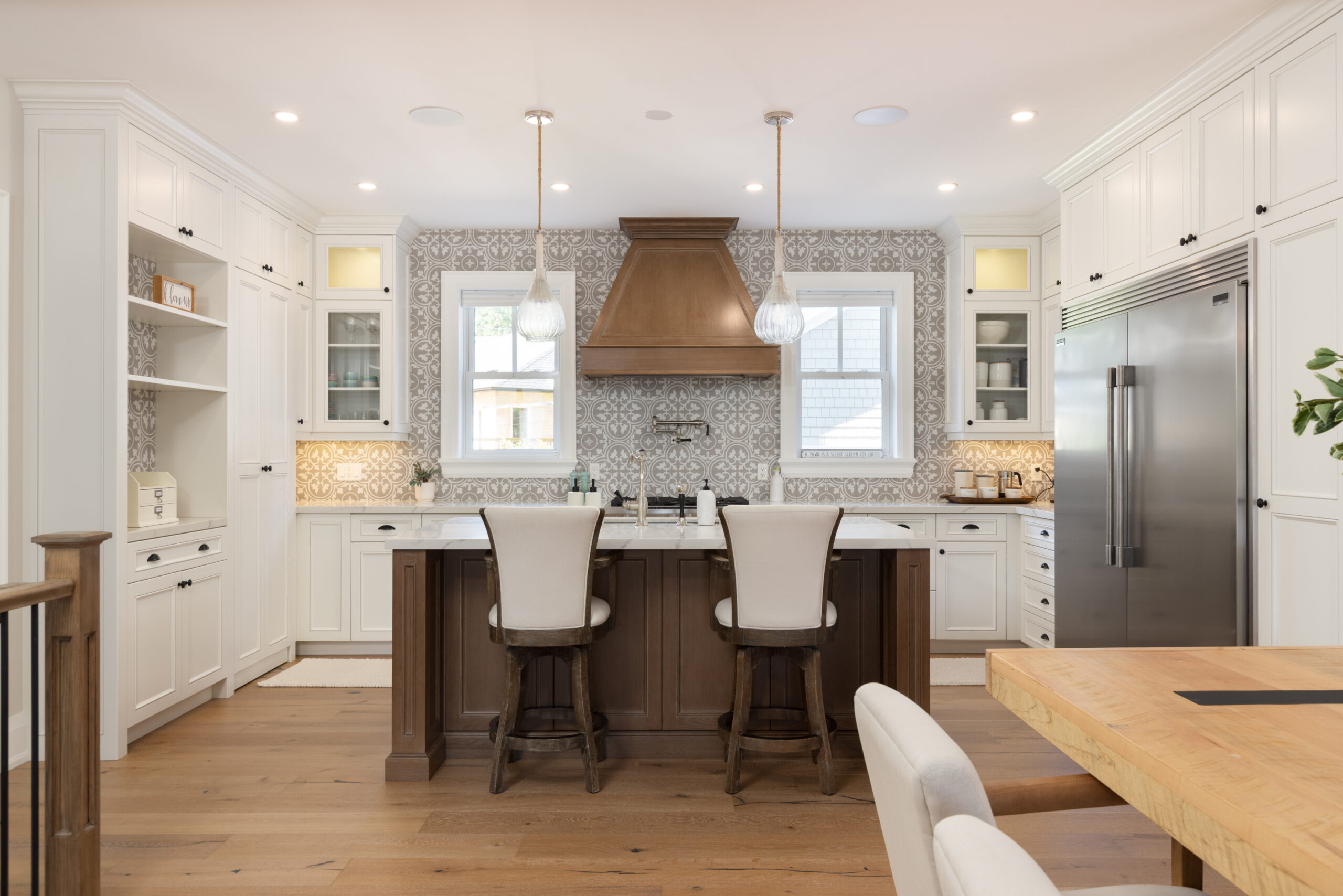 Modern kitchen with white cabinetry, wooden island, and pendant lights