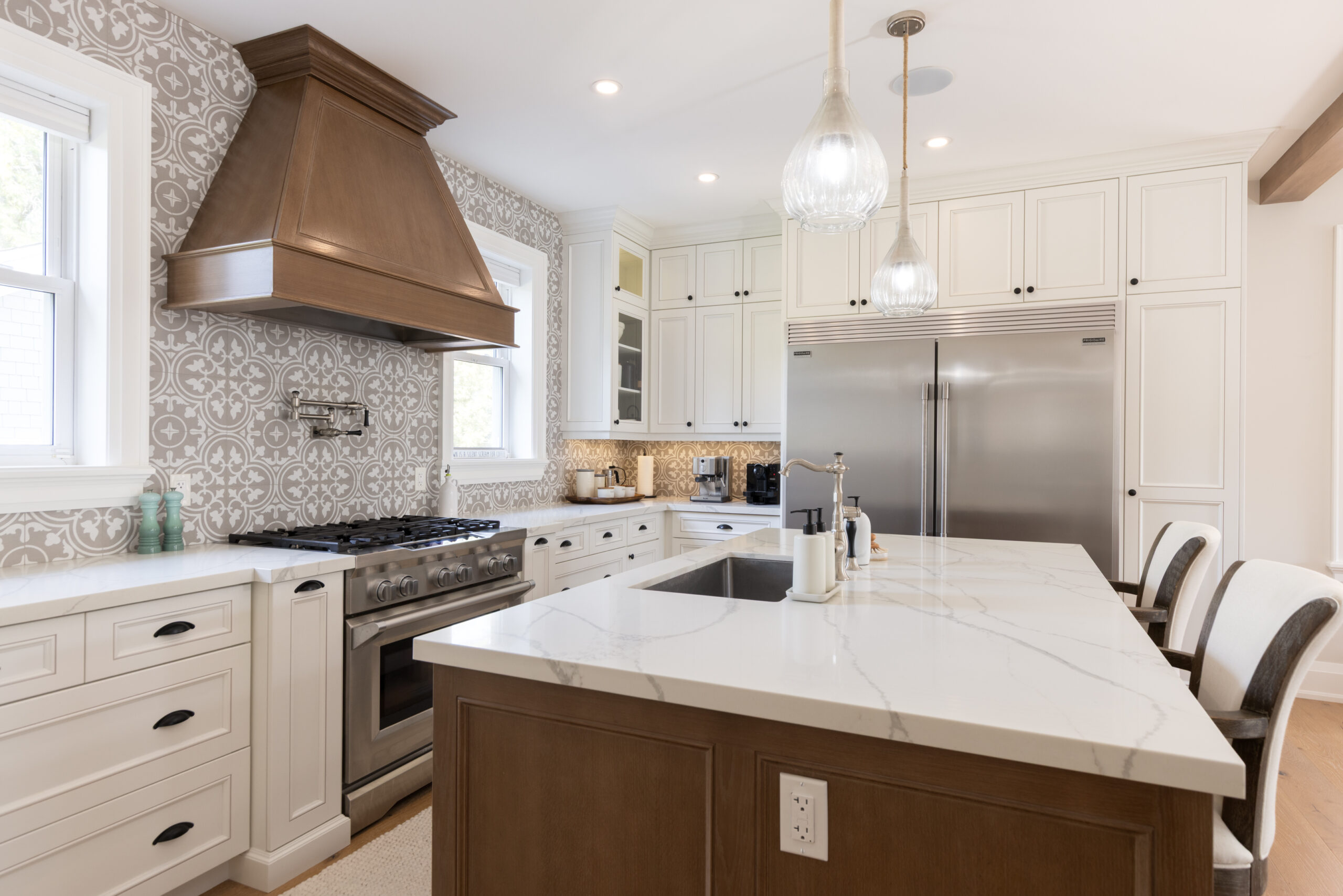 Modern kitchen with white cabinets, marble island, and stainless steel appliances