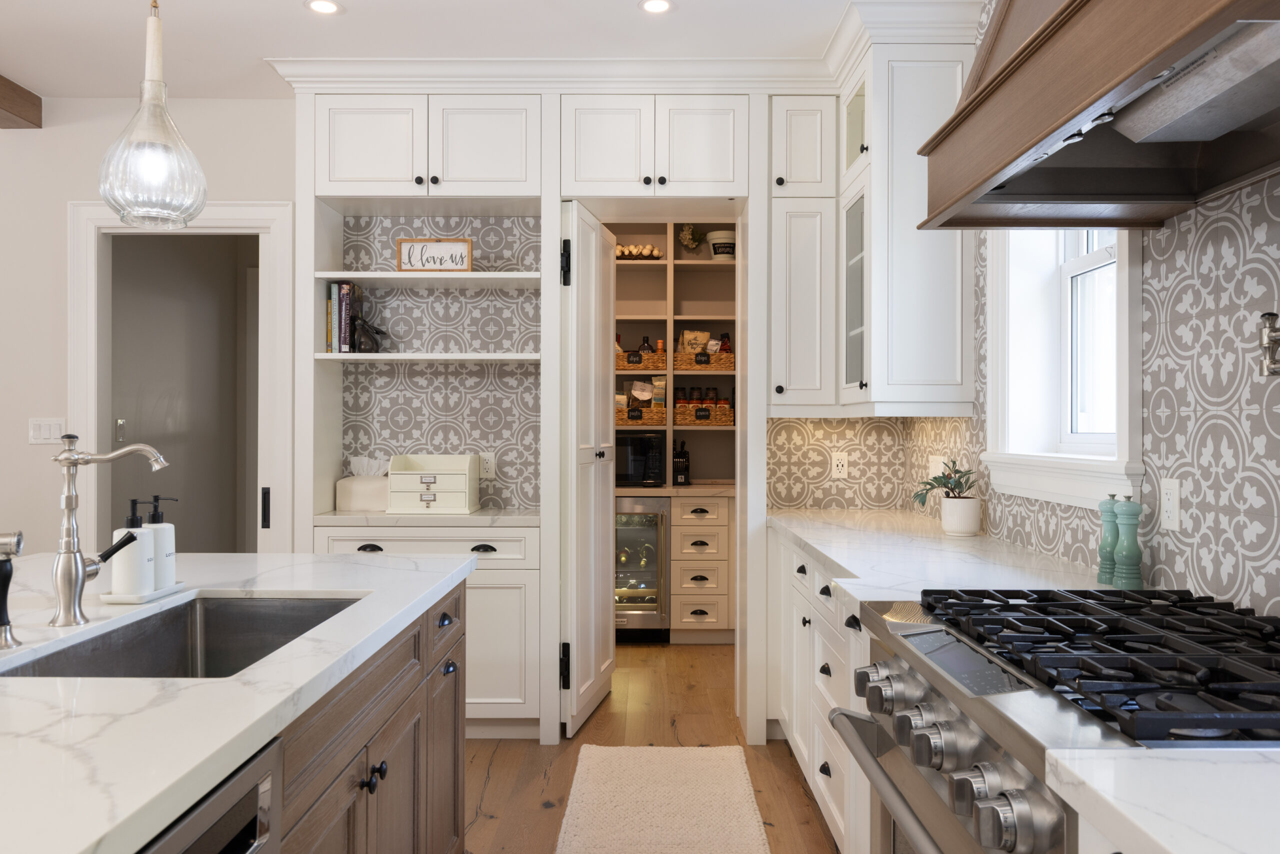 Modern kitchen with white cabinetry, marble countertops, and a gas stove