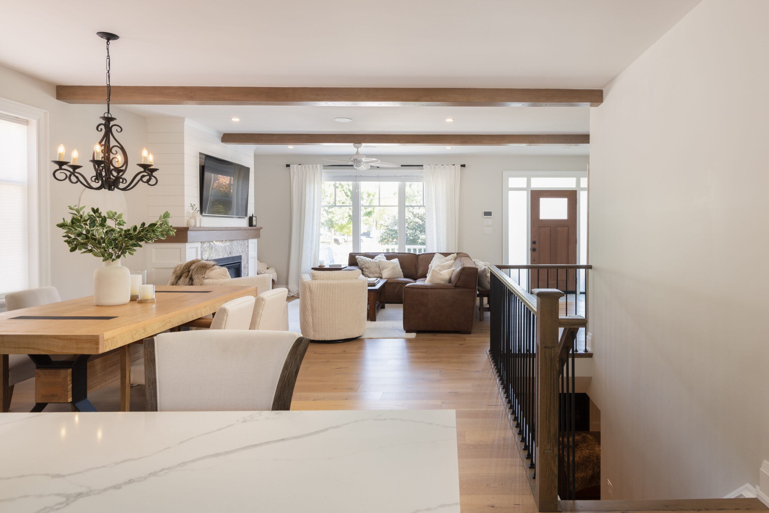 Bright open living space with dining table, chandelier, and cozy seating area