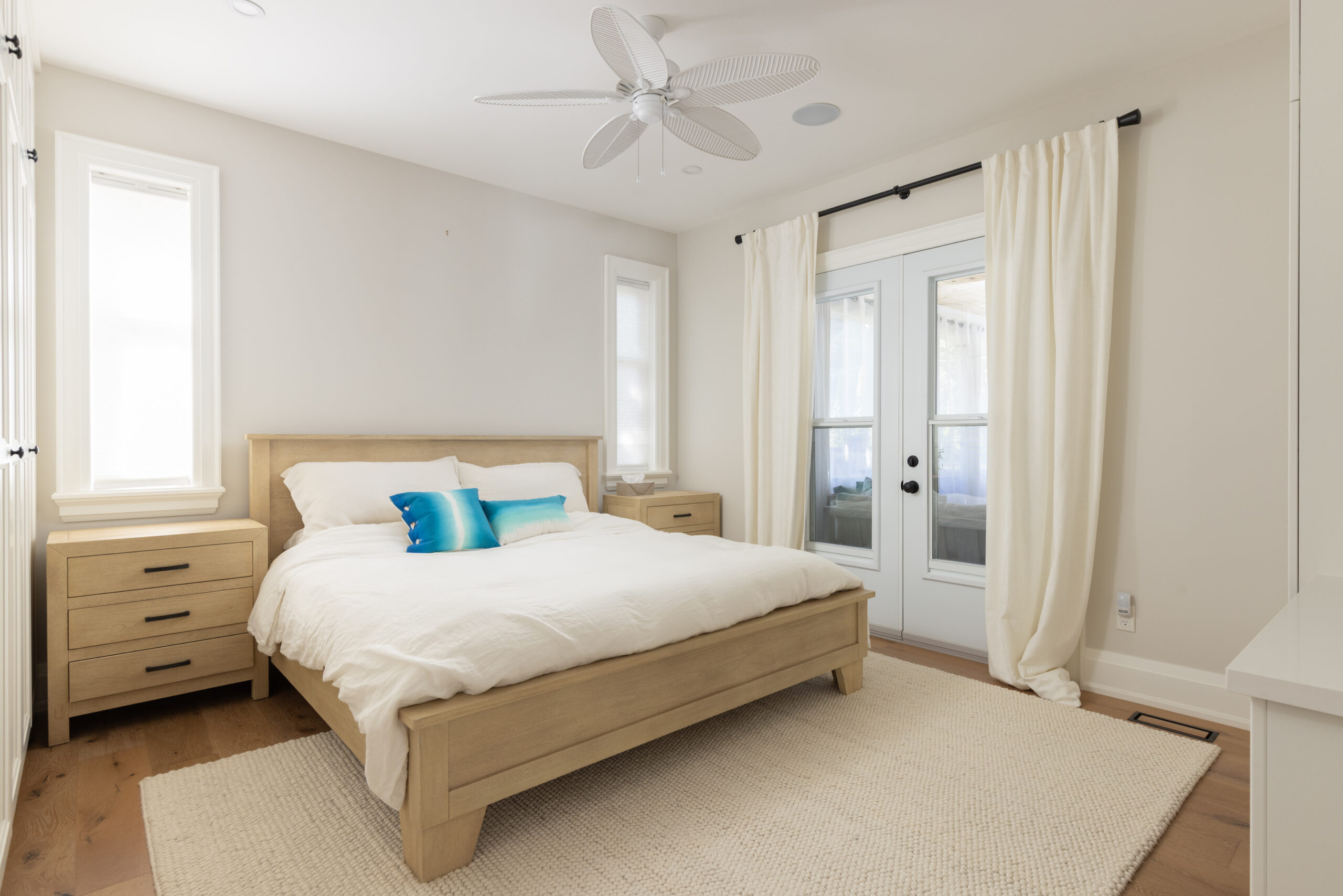 Bright bedroom with a wooden bed, blue pillows, and natural light