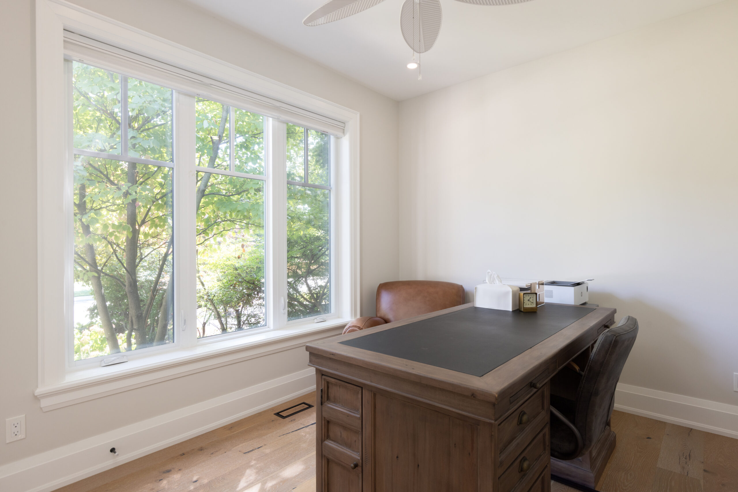 Bright home office with large windows and wooden desk