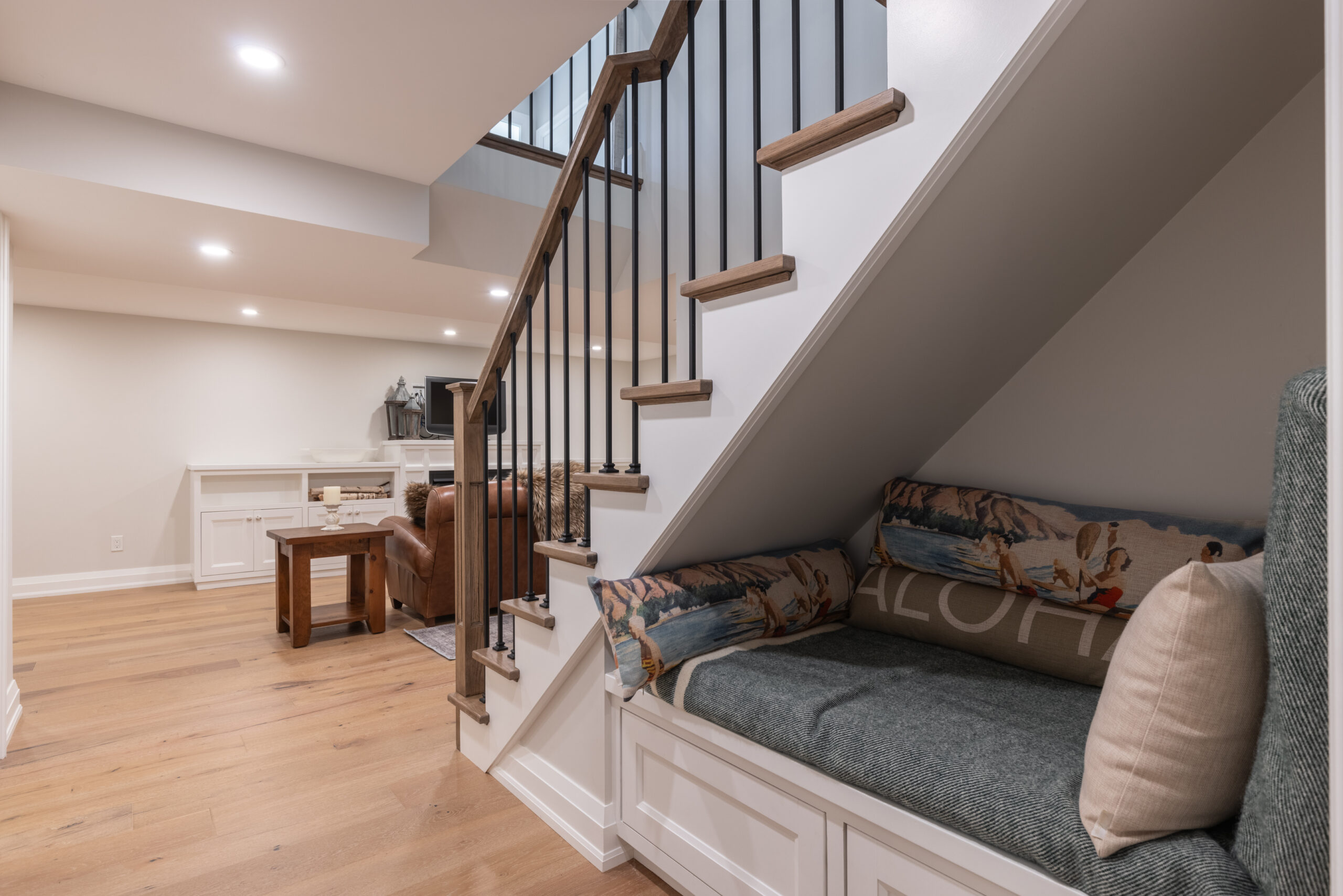 Cozy nook under stairs with seating and wooden staircase in modern interior