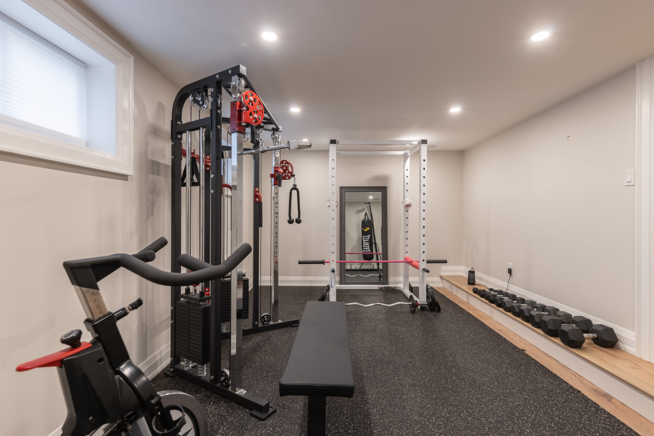 Home gym with exercise equipment, including weights and a workout bench