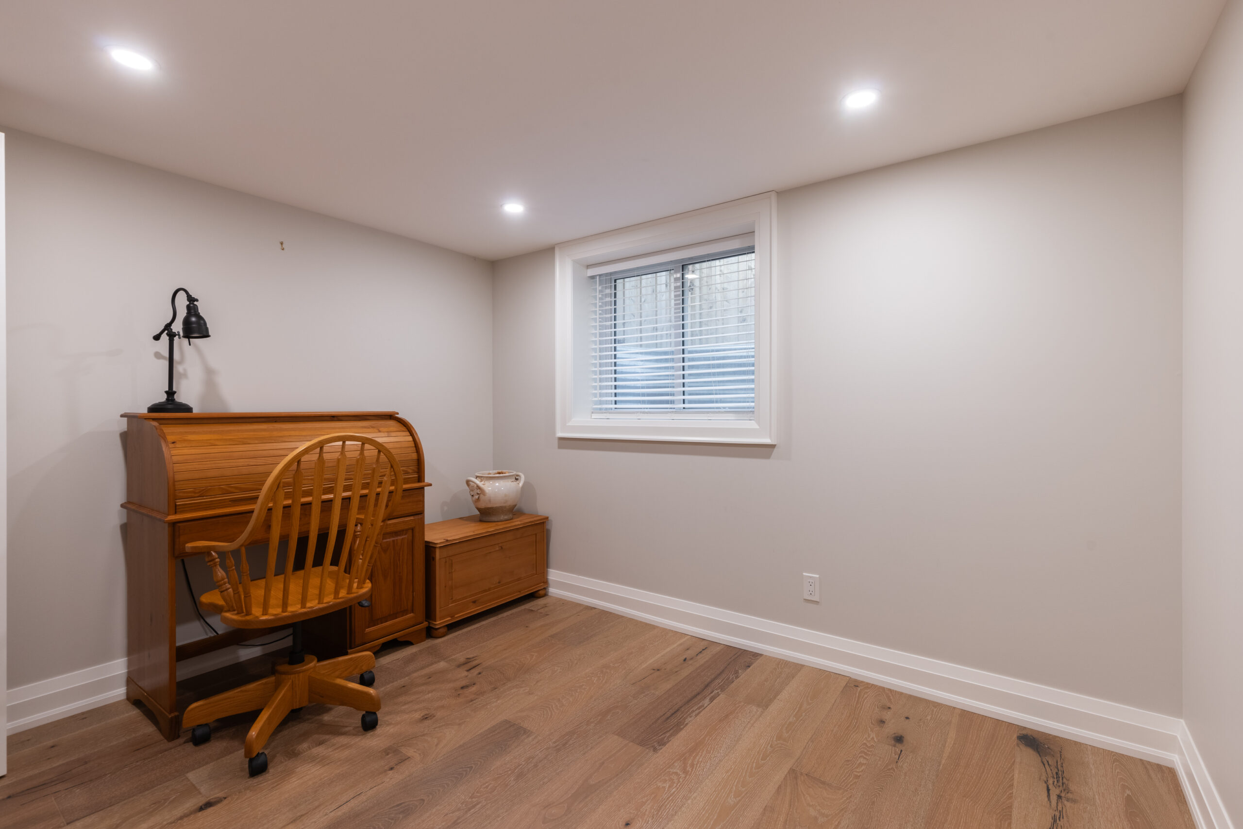 Cozy room with wooden desk, chair, and natural light from window