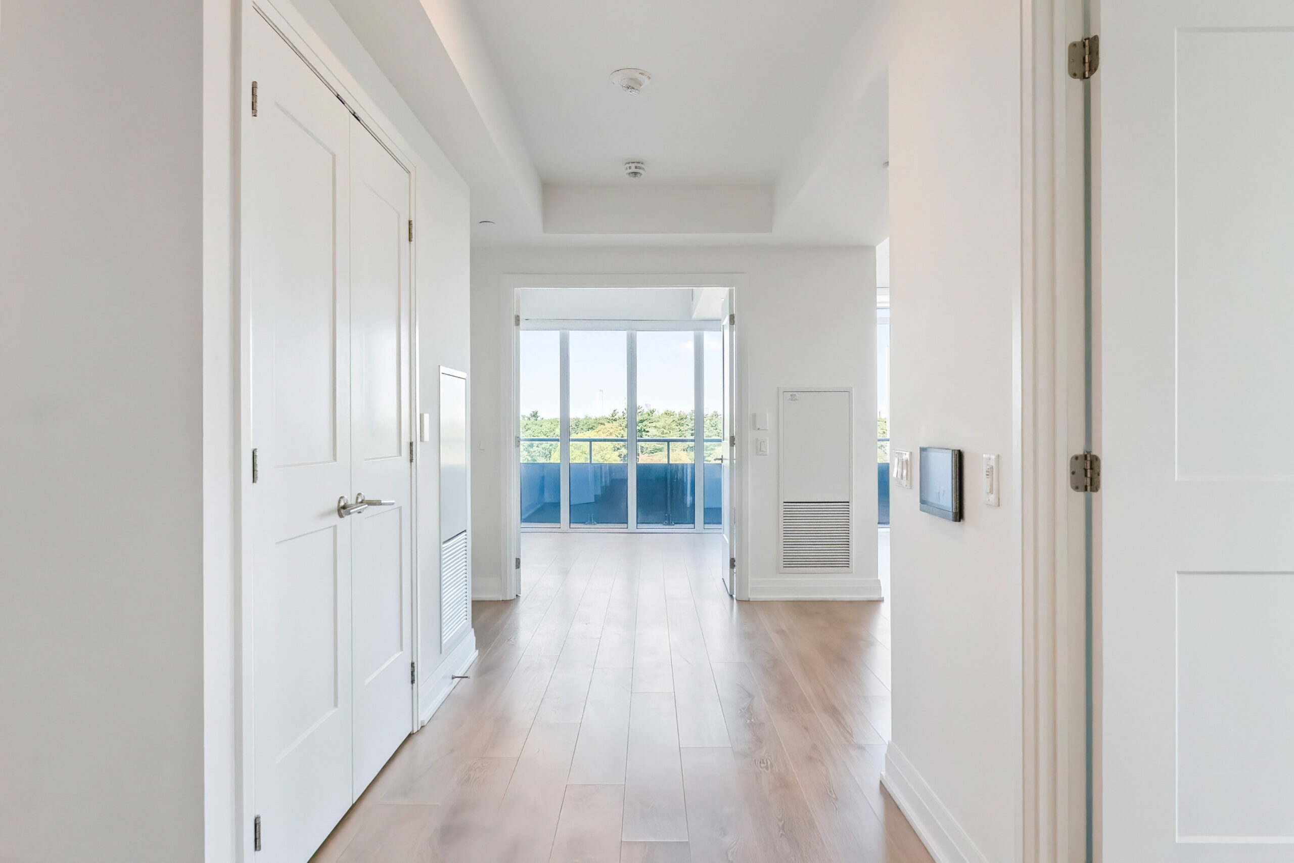 Bright hallway leading to a balcony with scenic views