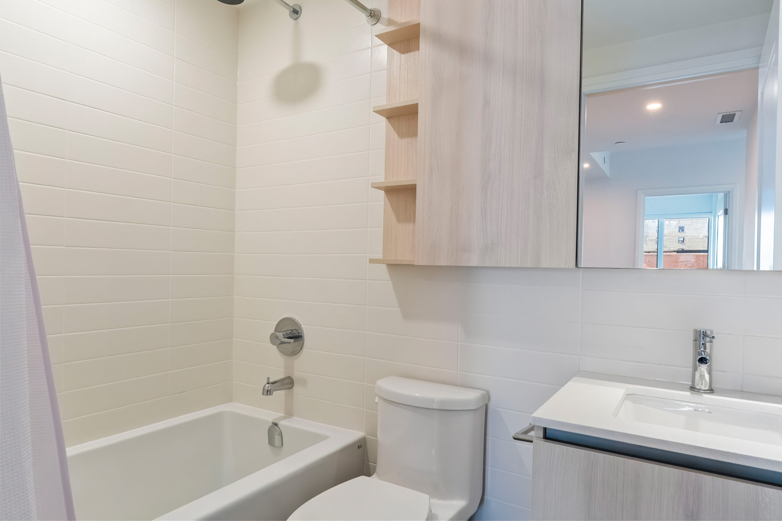 Modern bathroom featuring a bathtub, toilet, and sleek cabinetry