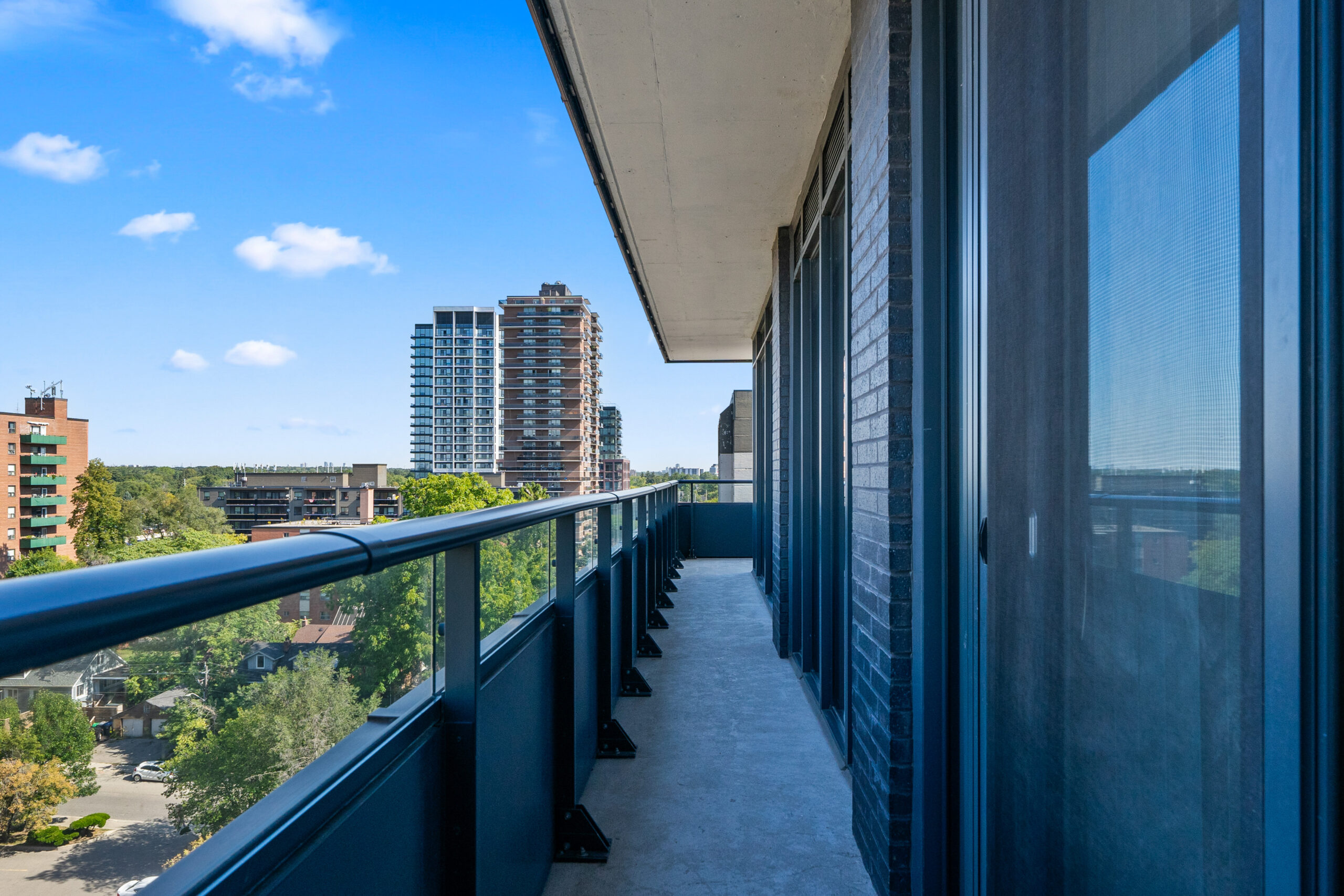 Balcony view overlooking city buildings and blue sky