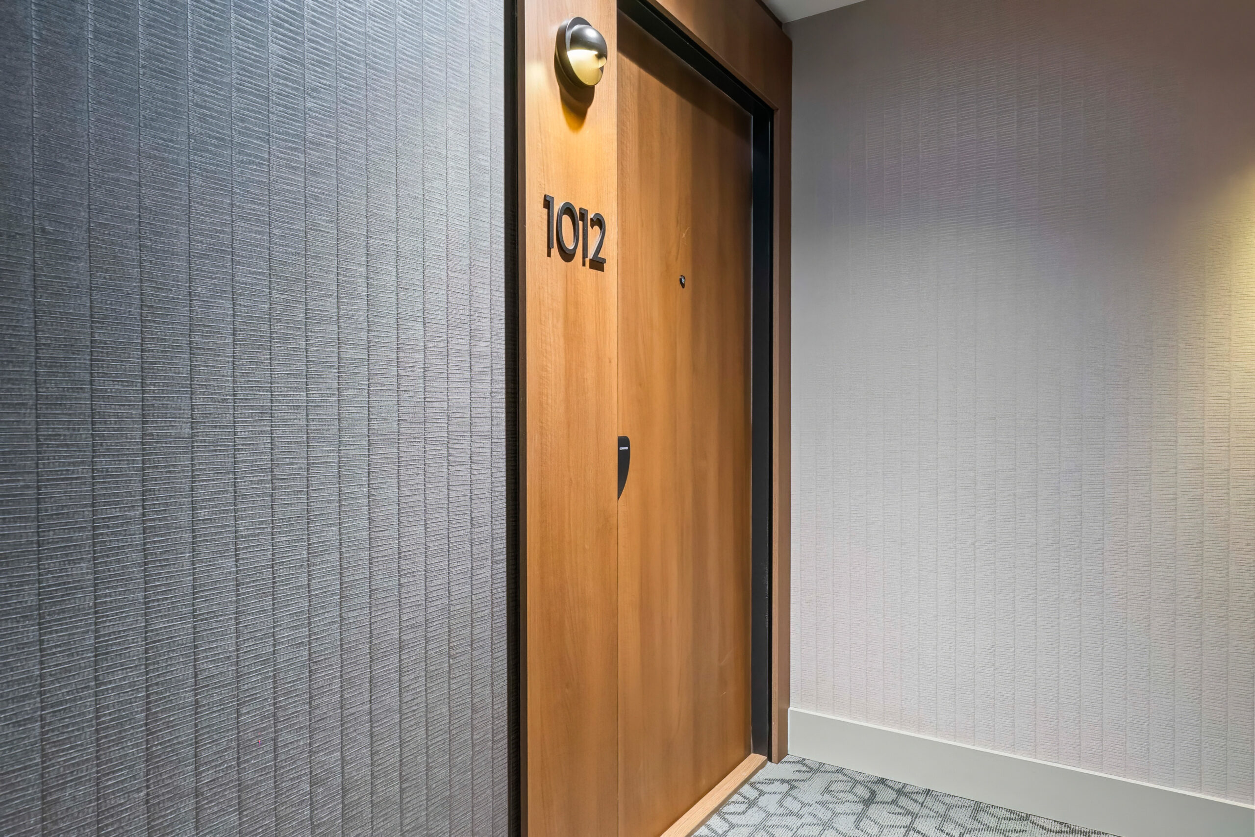 Wooden door with the number 1012 in a hotel corridor