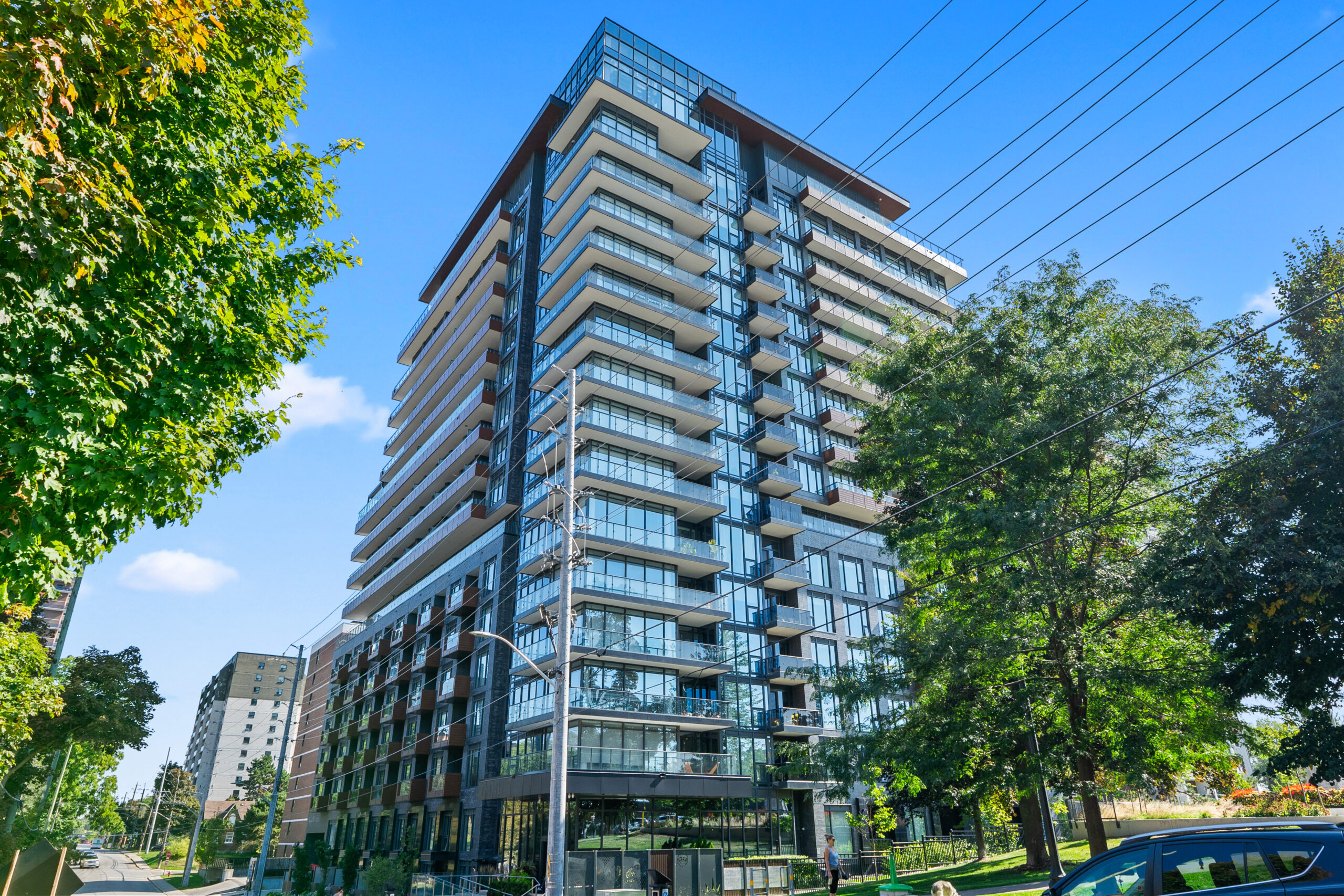 Modern residential building with large windows and balconies against a clear blue sky