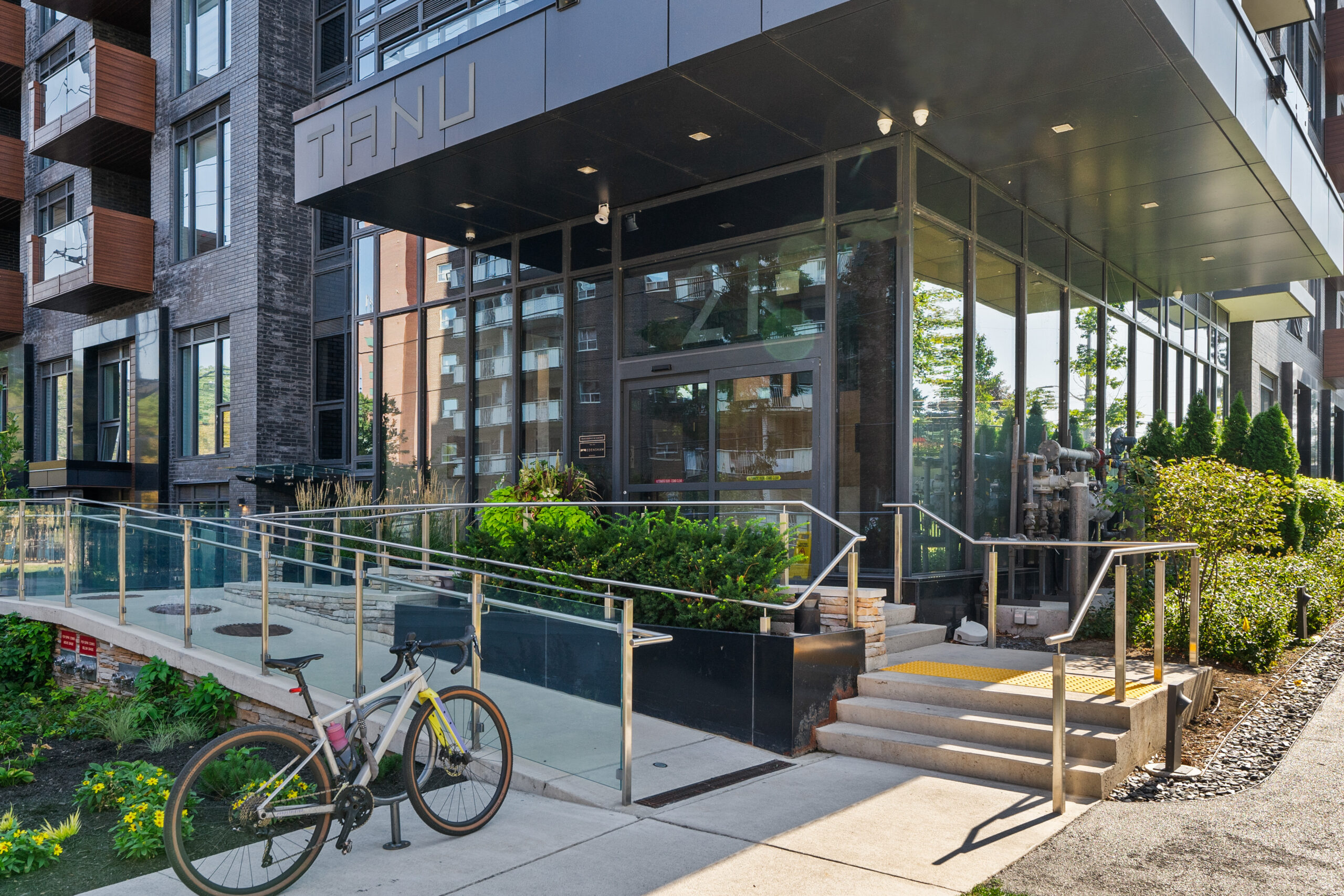 Modern building entrance with glass doors and bike parked nearby