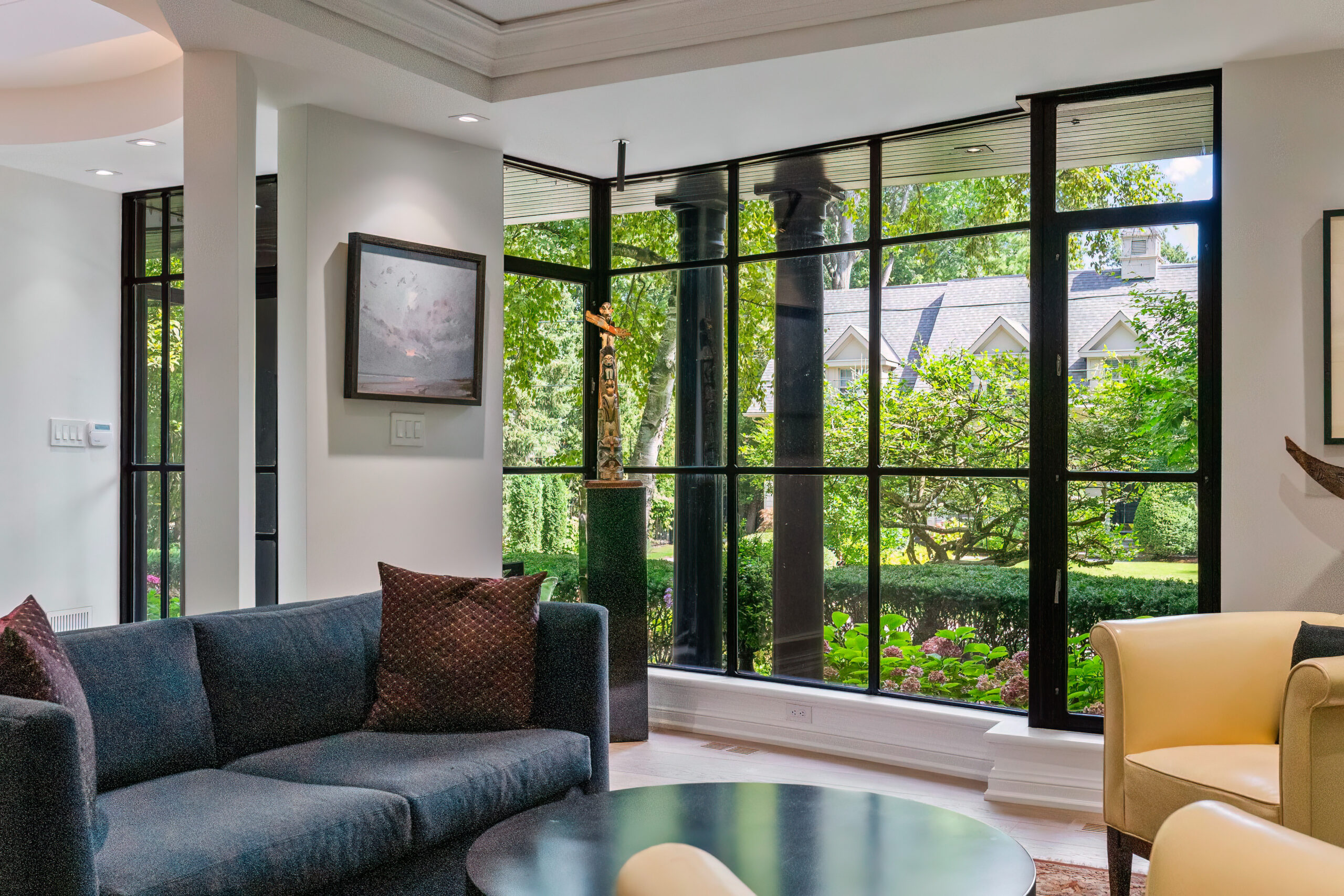 Modern living room with large windows overlooking a lush garden