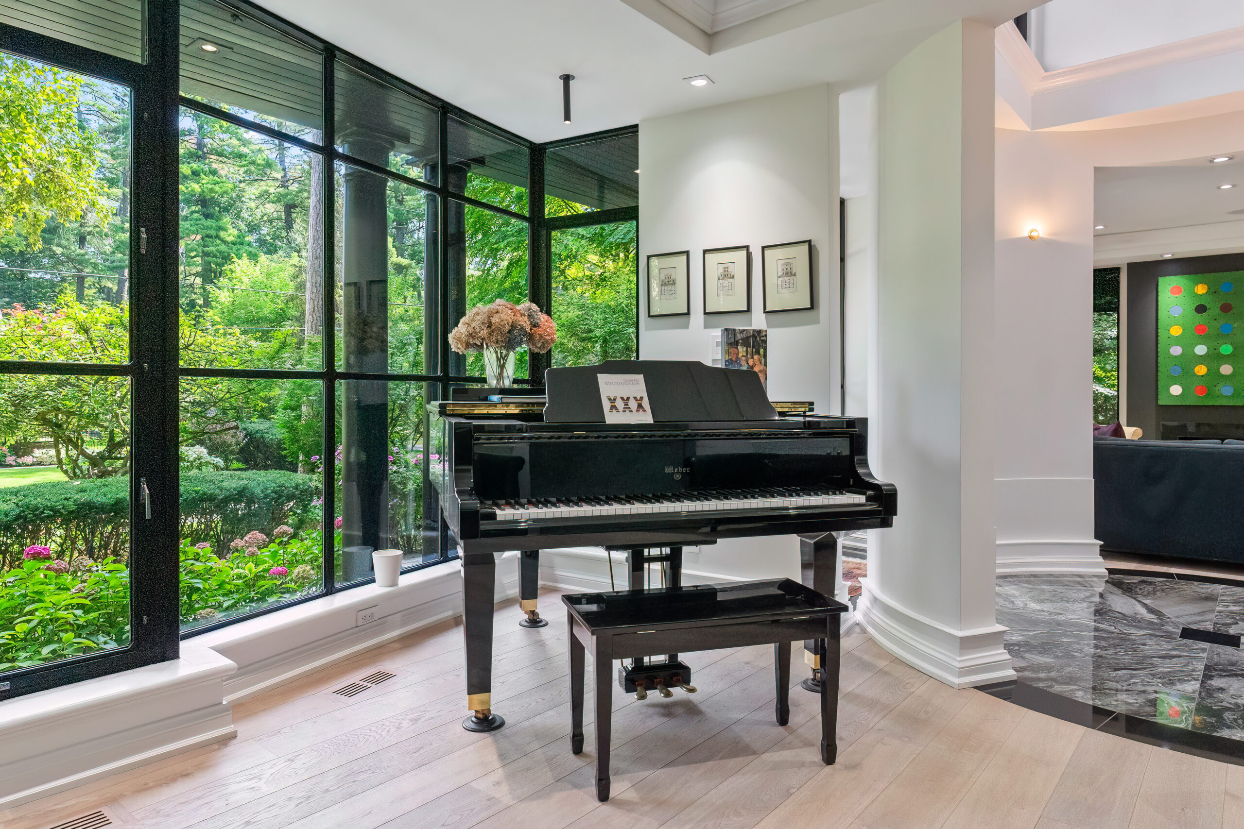 Grand piano in a bright room with large windows and garden view