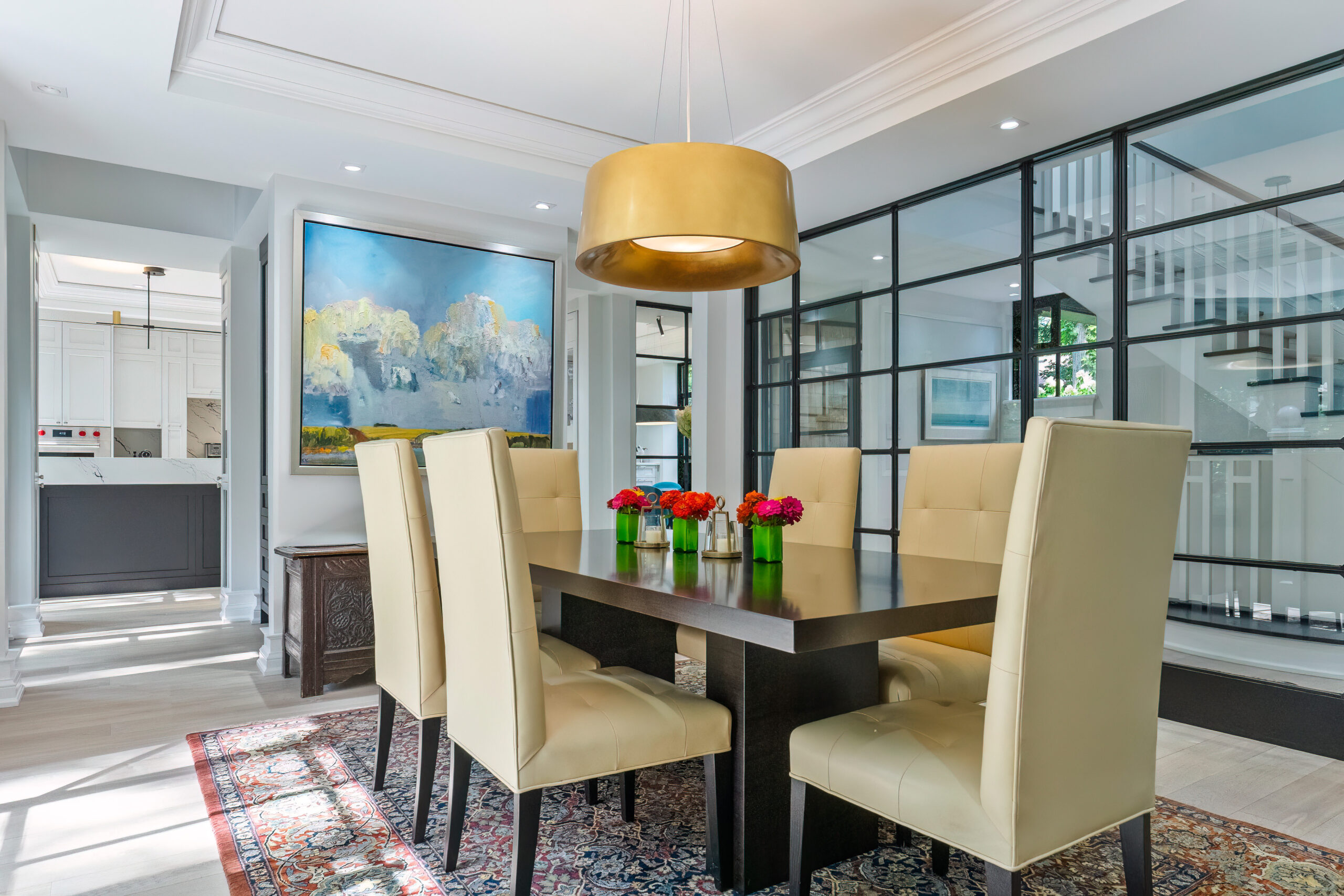 Modern dining room with a wooden table, yellow pendant light, and floral centerpiece