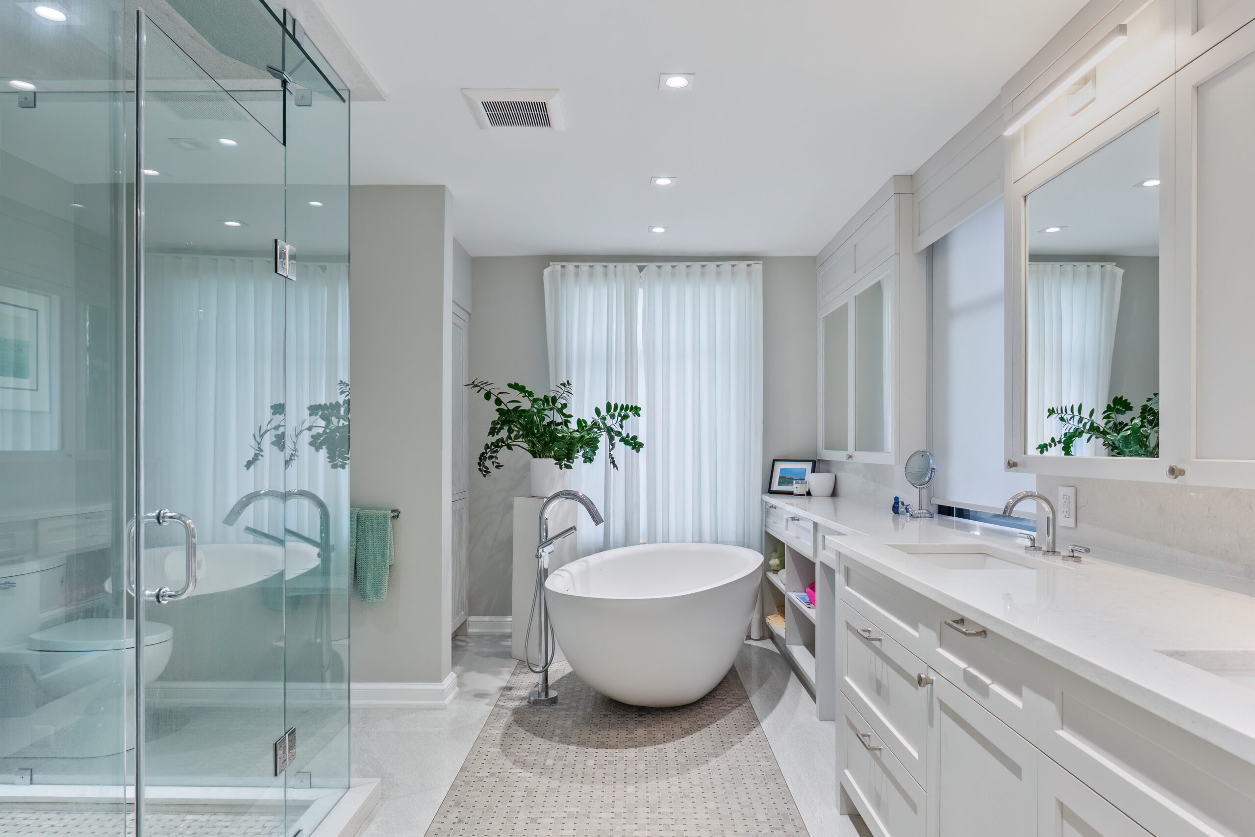 Modern bathroom featuring a freestanding tub, glass shower, and natural light.