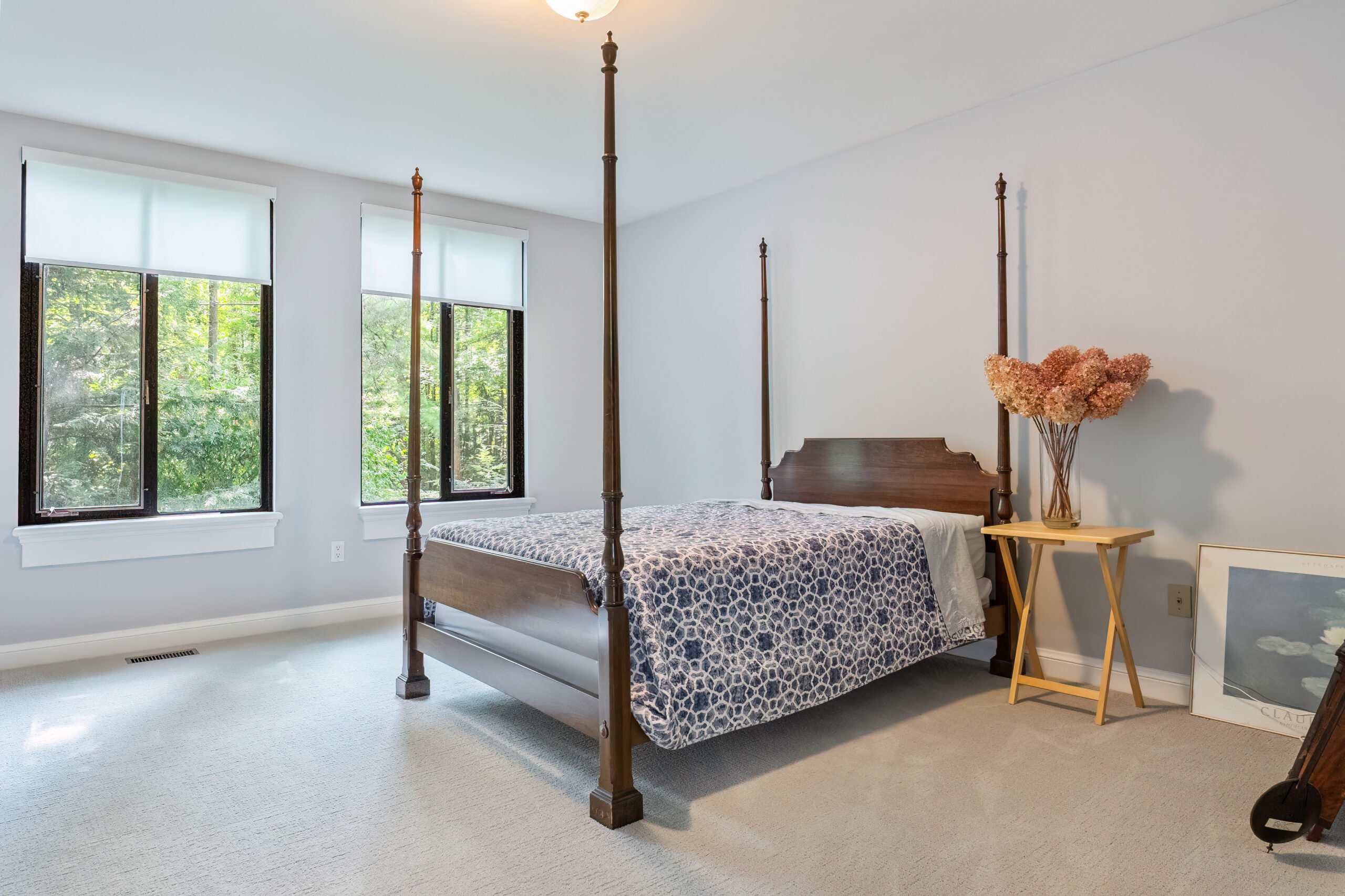 Bright bedroom featuring a four-poster bed and large windows