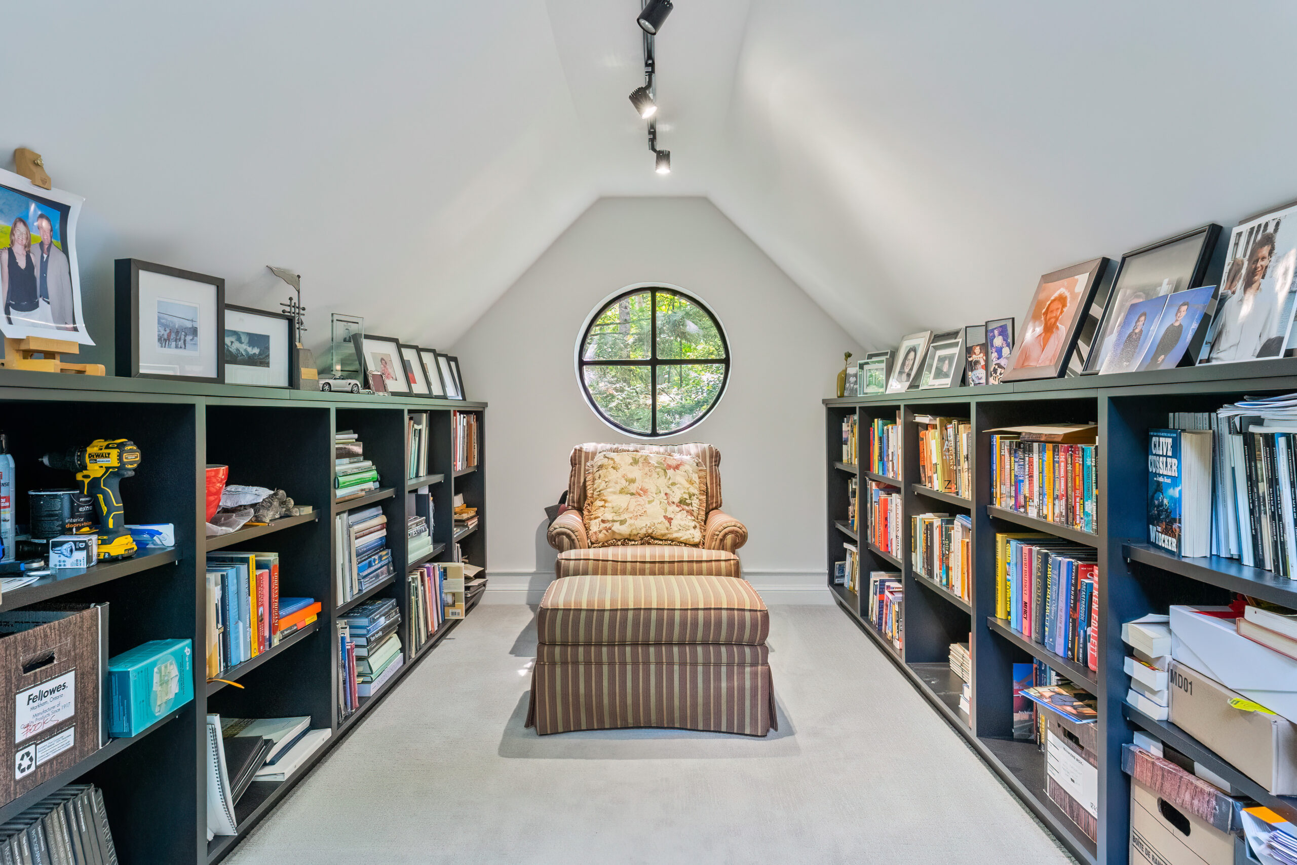 Cozy attic library with bookshelves and a round window