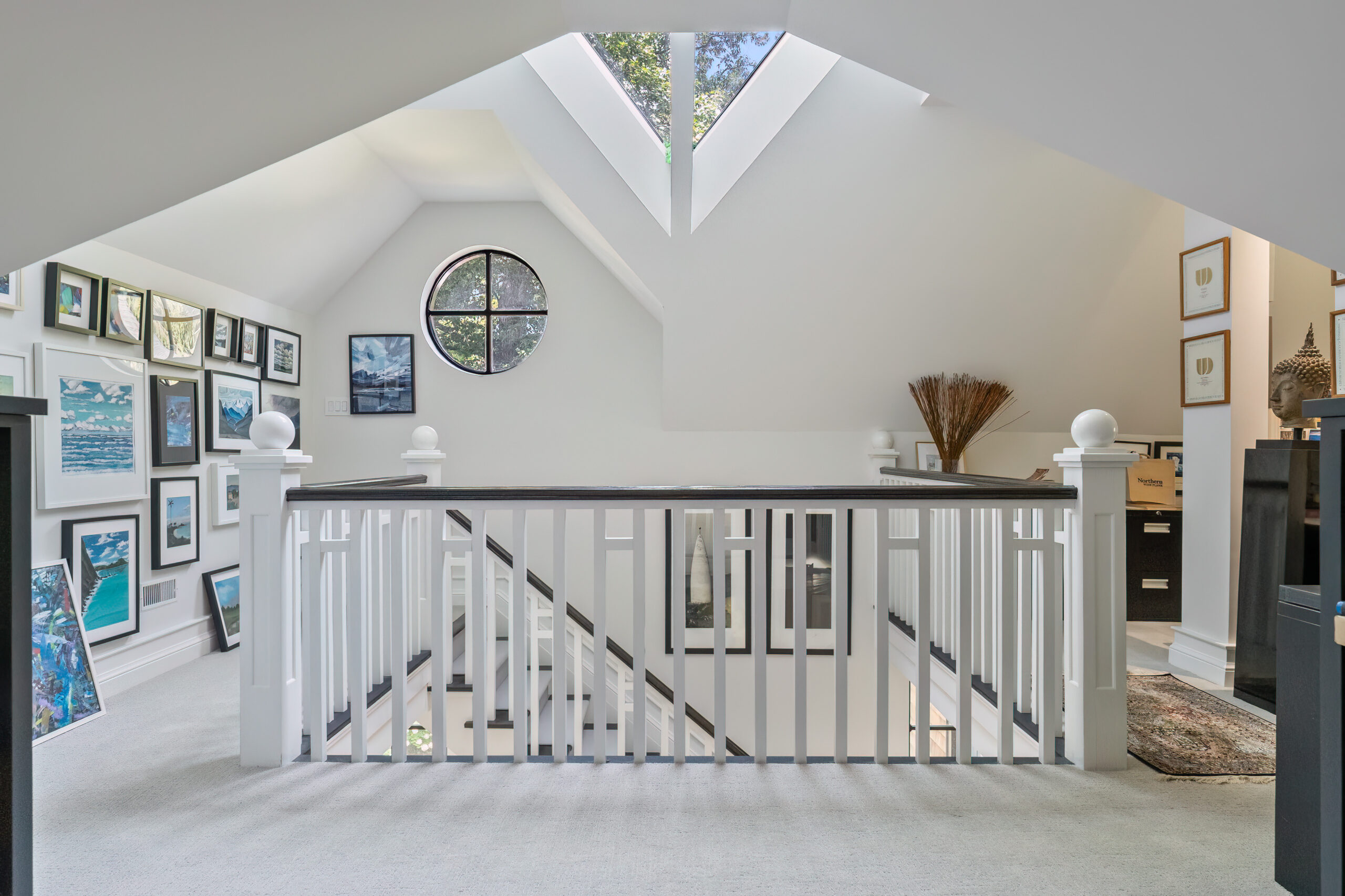 Bright, airy loft space with skylights and framed artwork on walls