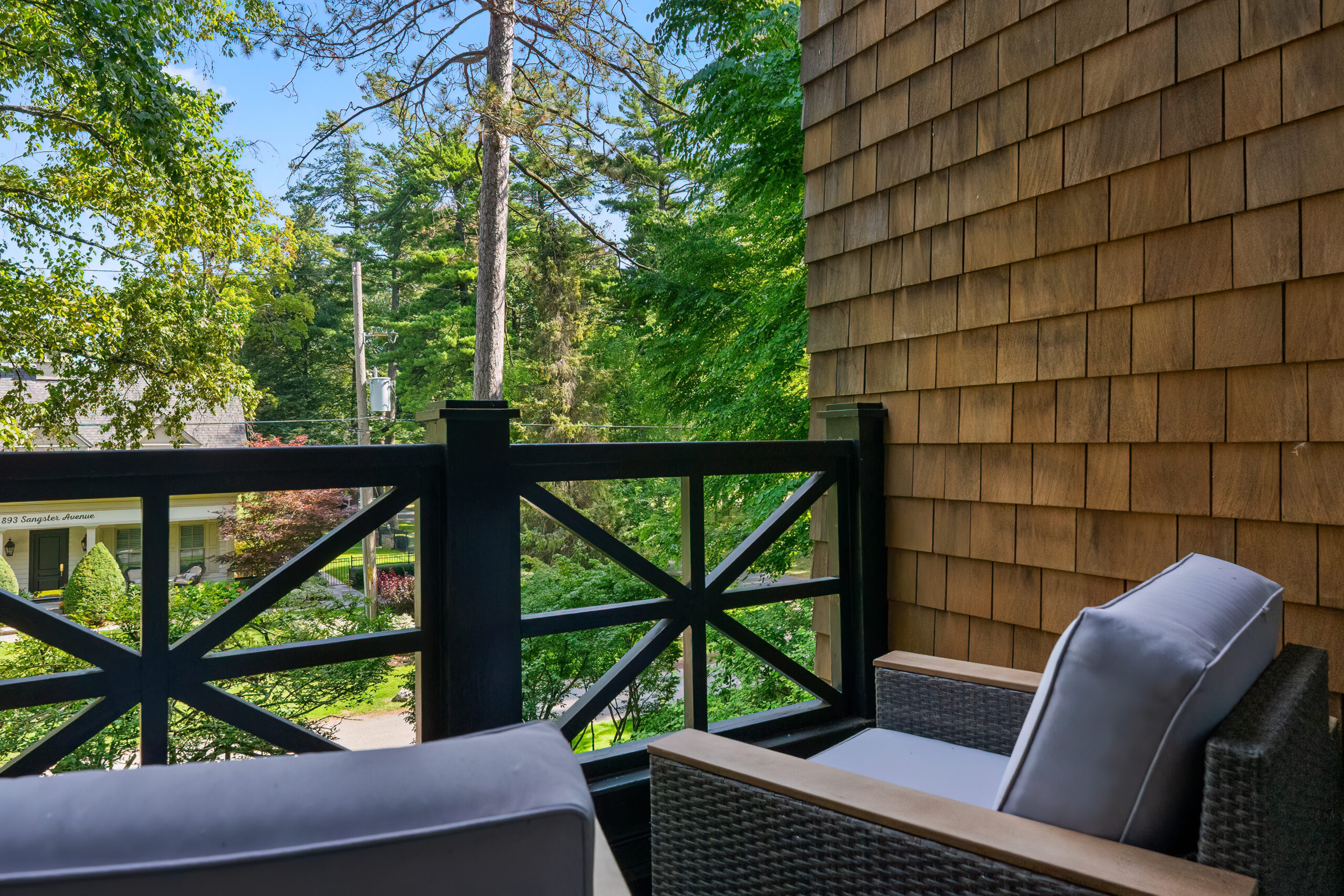 Cozy balcony view with two chairs and lush greenery in the background