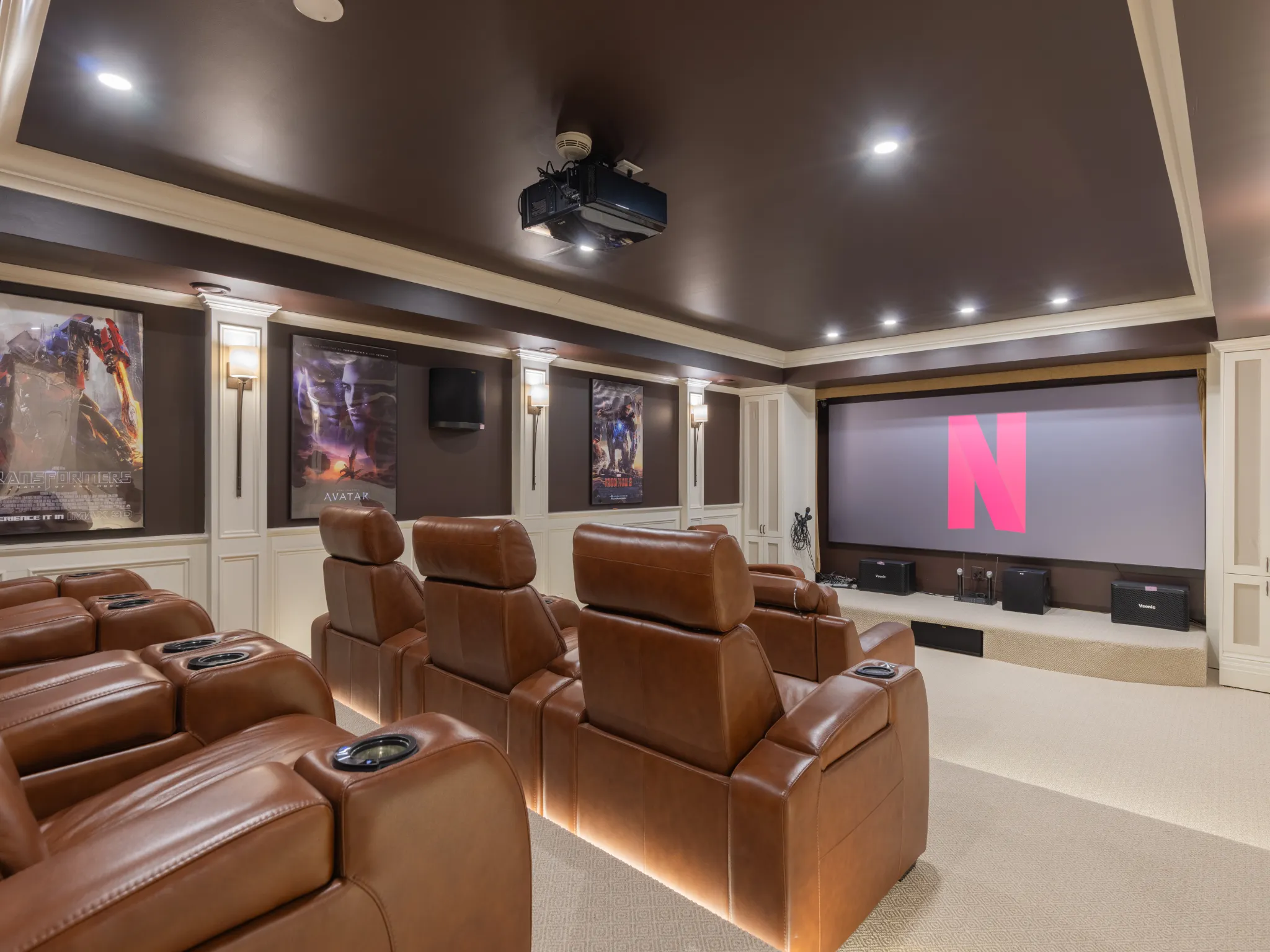 carpeted theater room with crown molding, recessed lighting and luxurious chairs