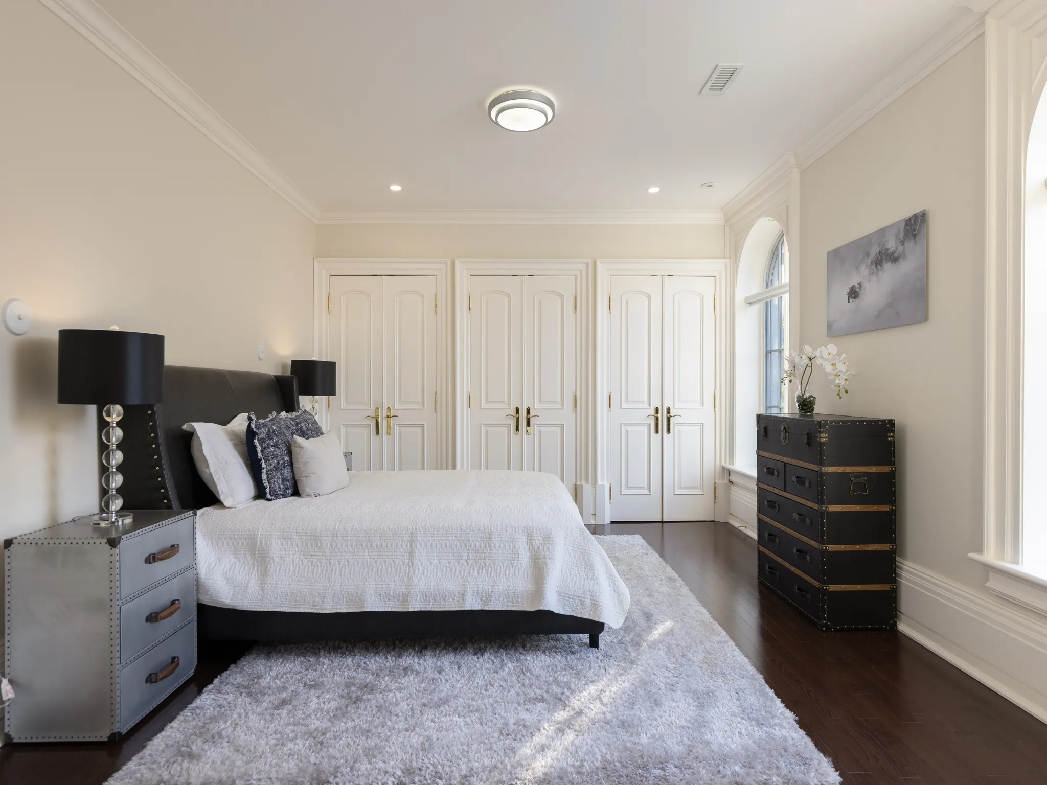 bedroom featuring multiple closets and arch windows