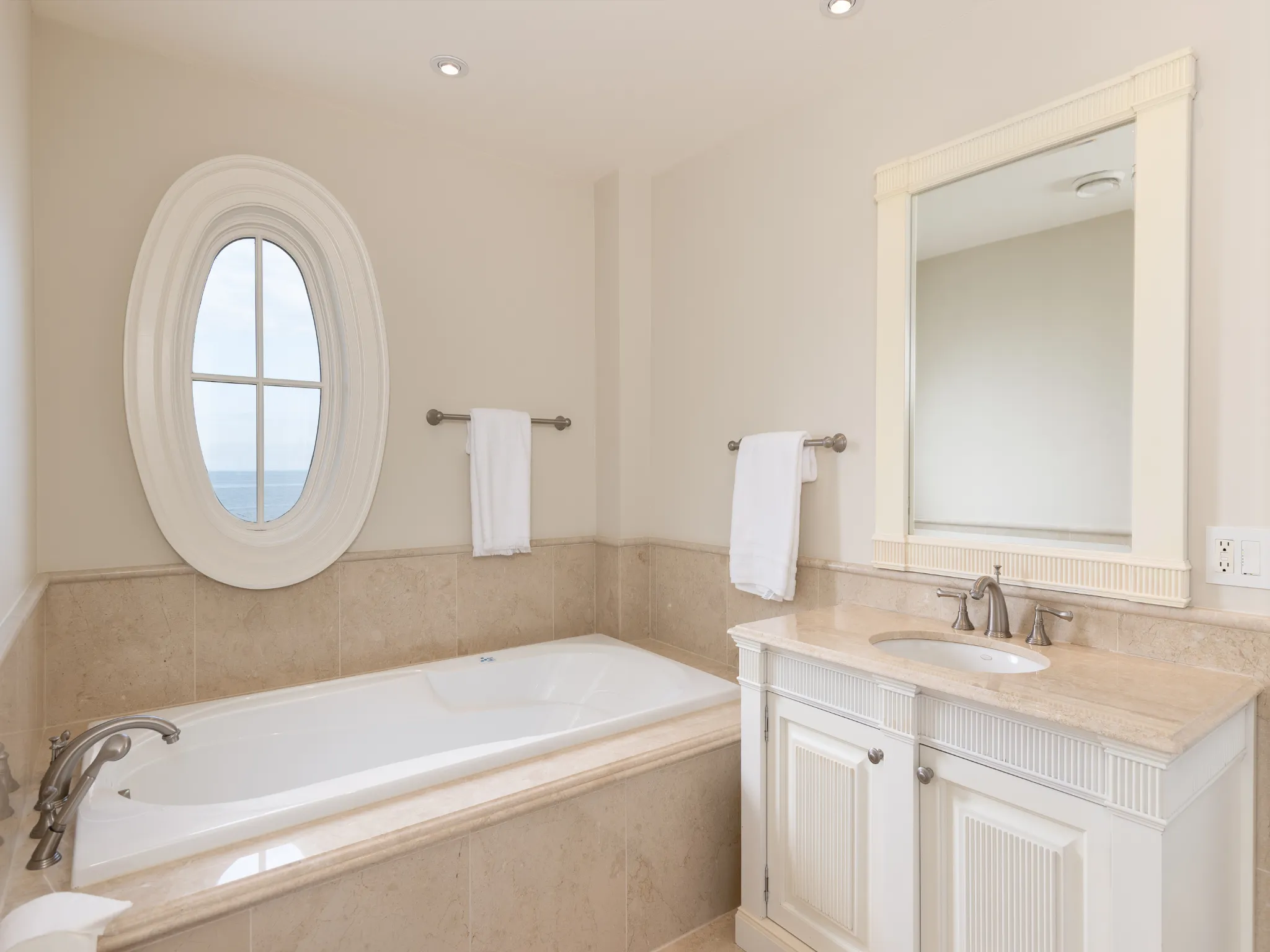 bathroom with soaker tub, vanity and recessed lighting