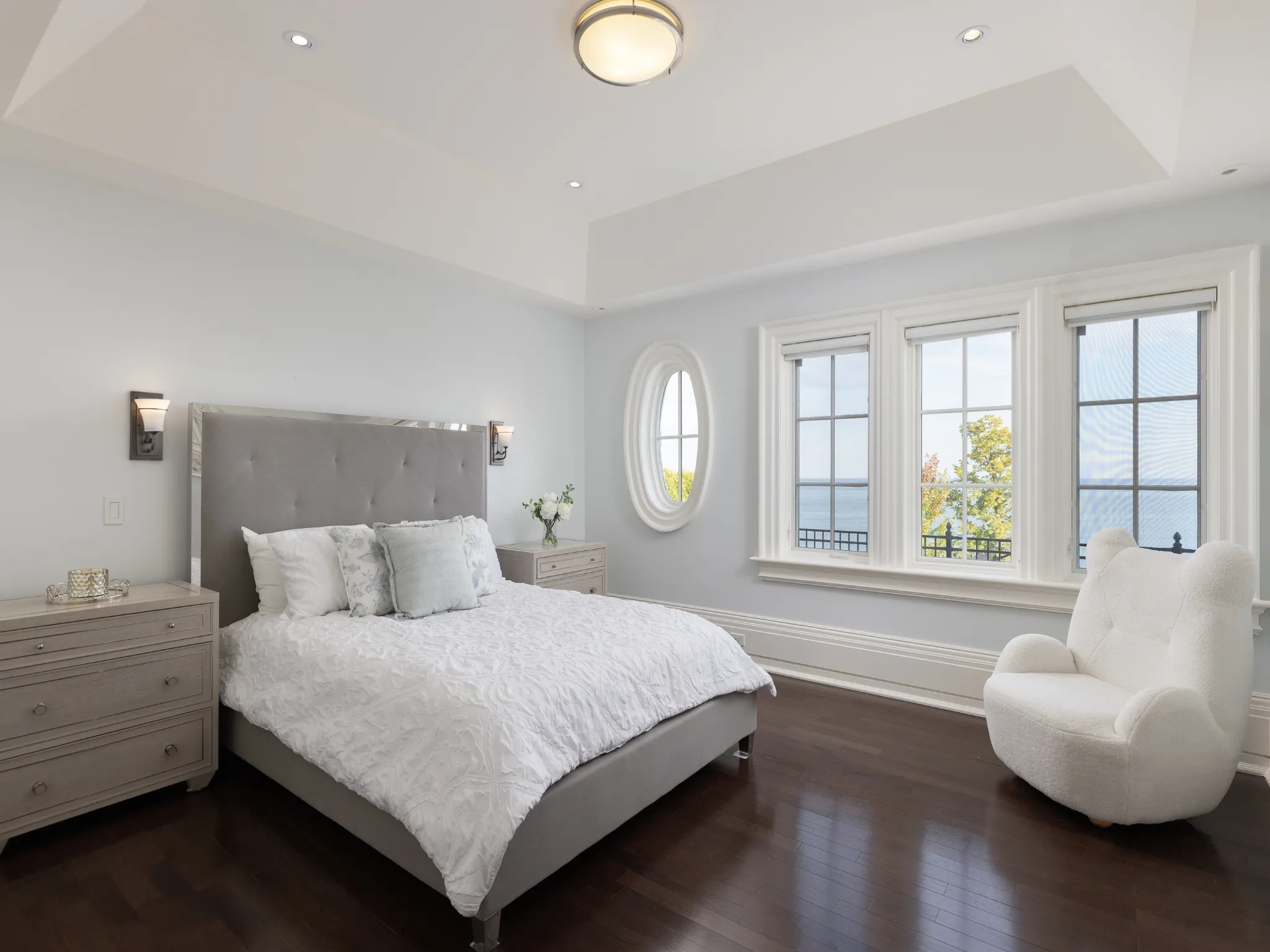 bedroom with dark woo d floors and white chair