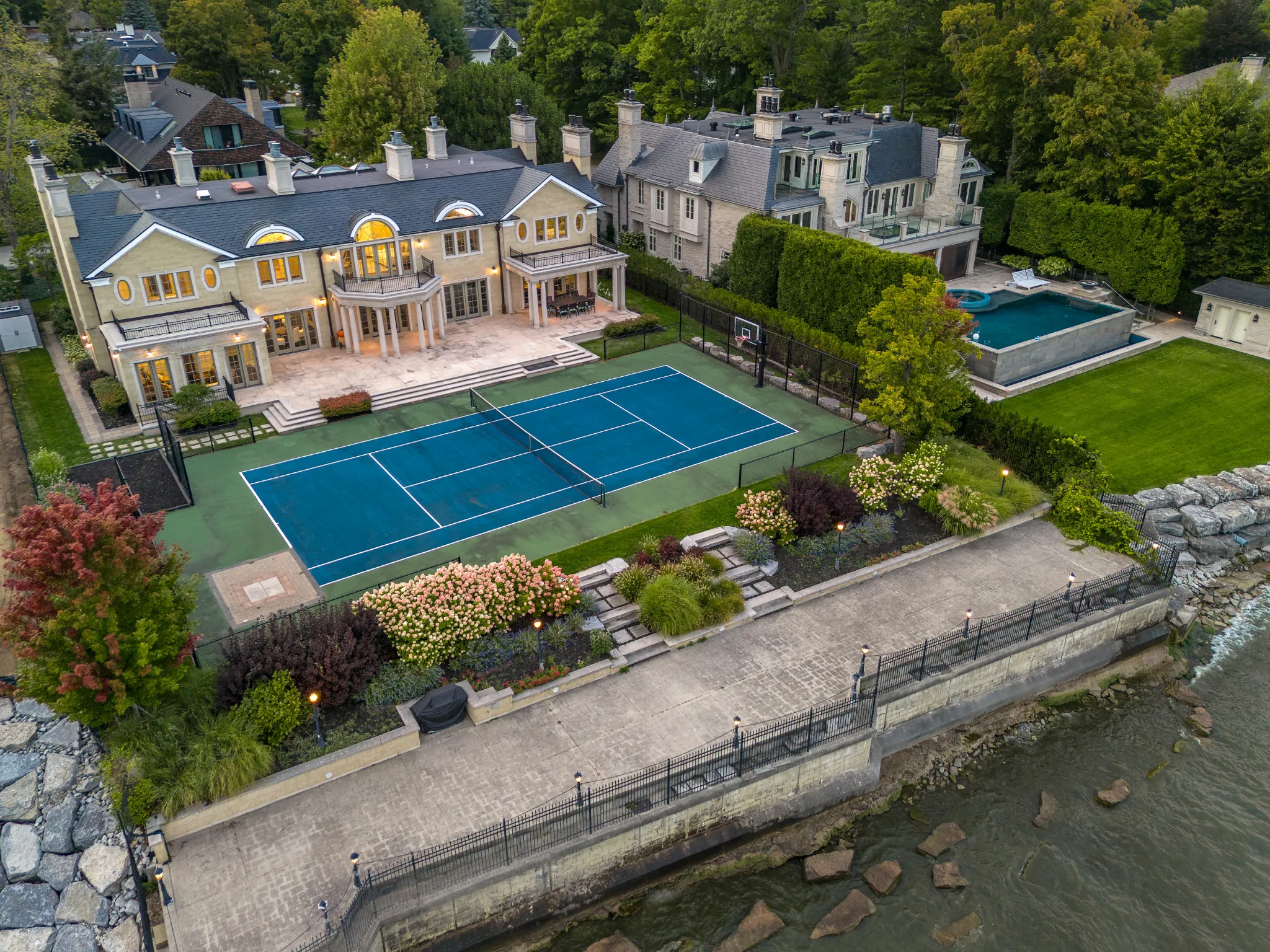 exterior of the home in the backyard showing the tennis court