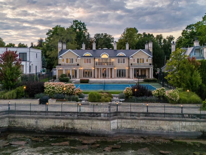 back of the property featuring patios, tennis court, seawall and views of lake ontario
