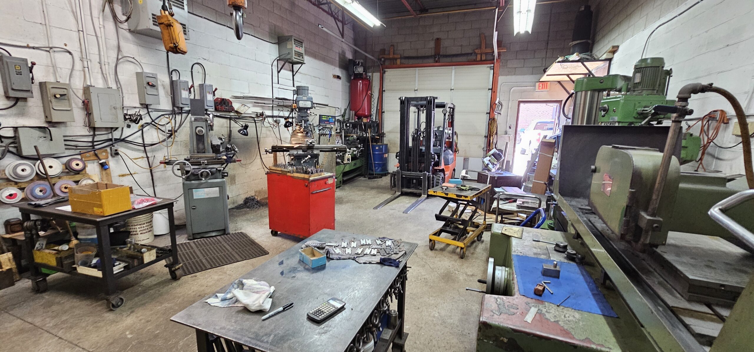 A spacious workshop with various machines and tools scattered around