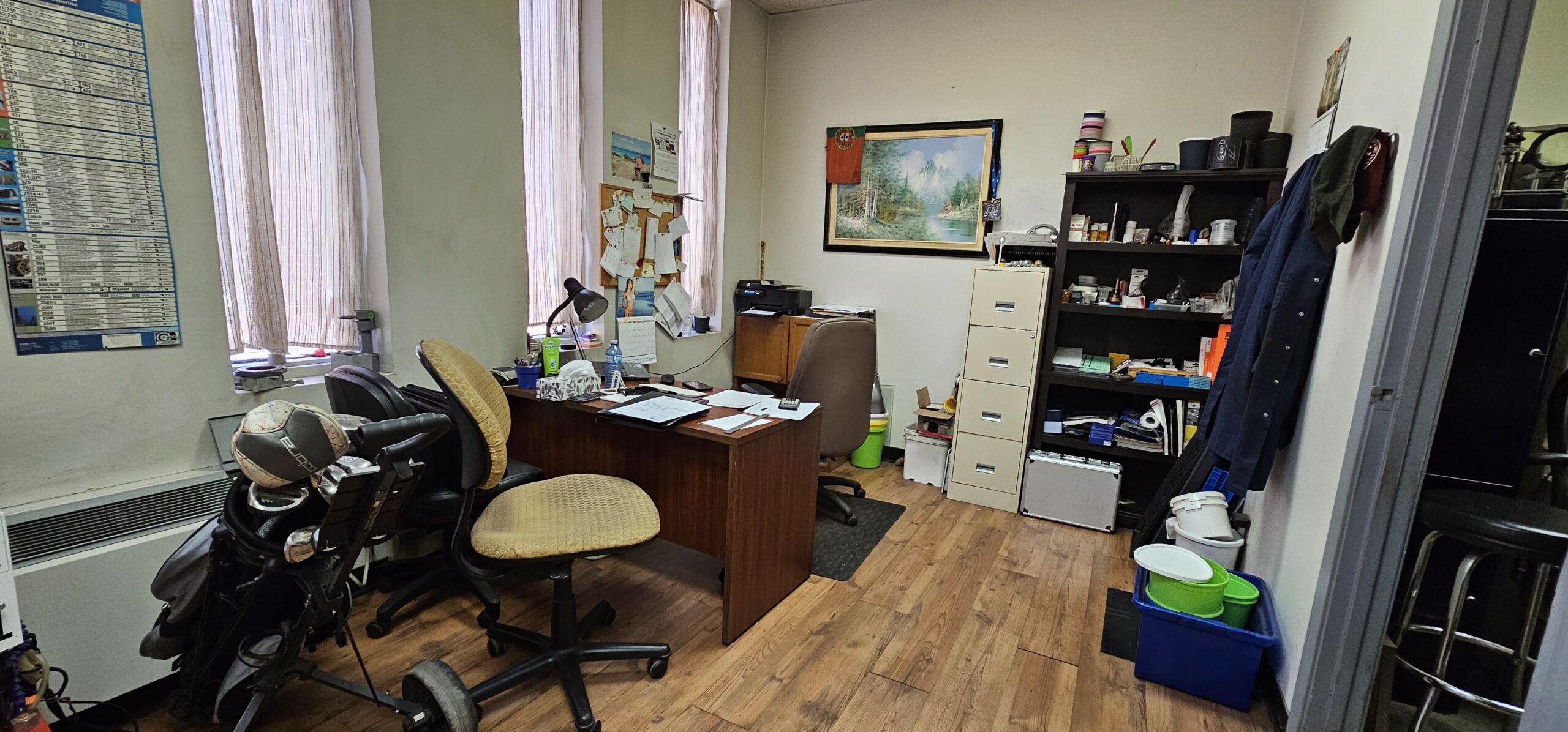 Office space with a desk, chair, and shelves filled with items