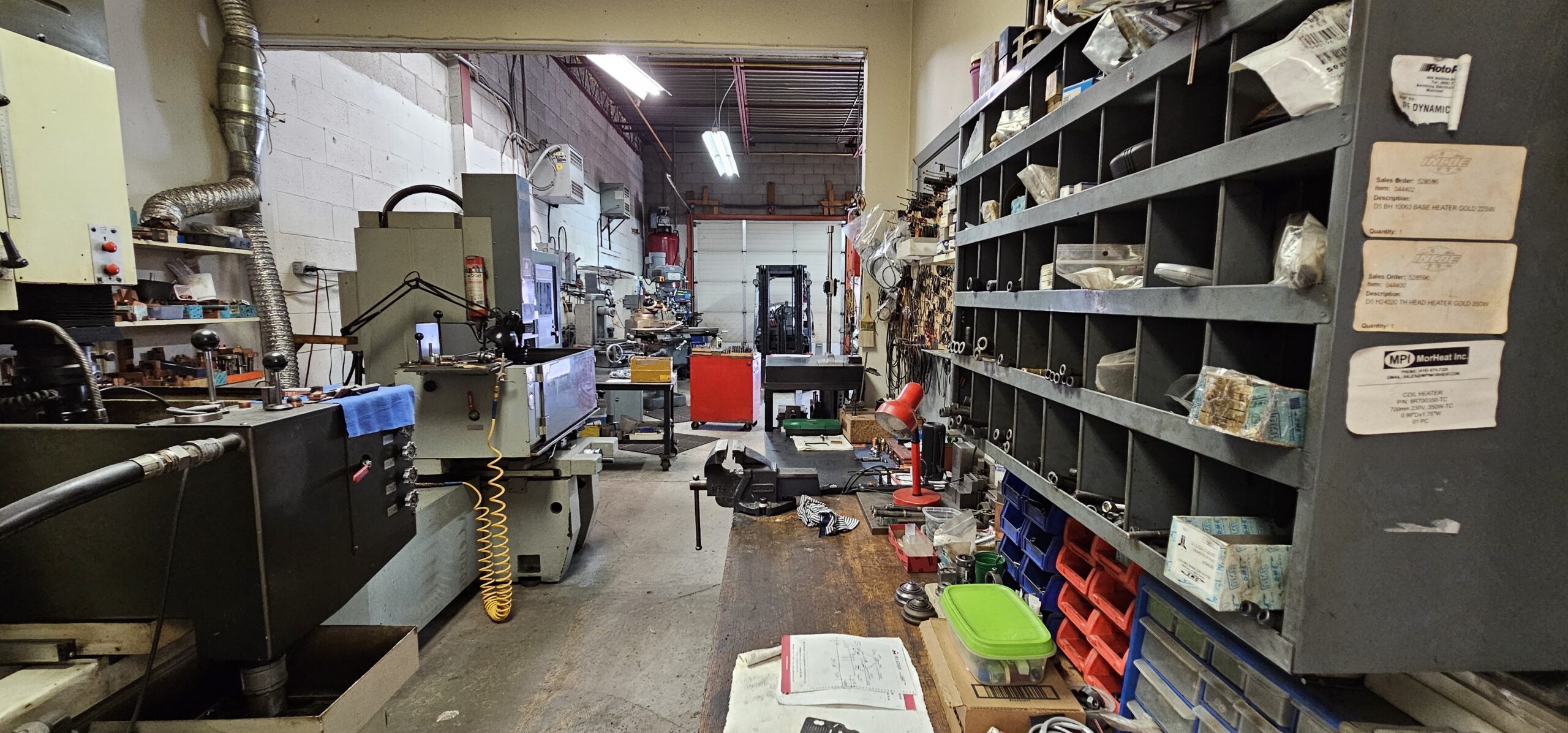A workshop with machinery, shelves, and various tools scattered around