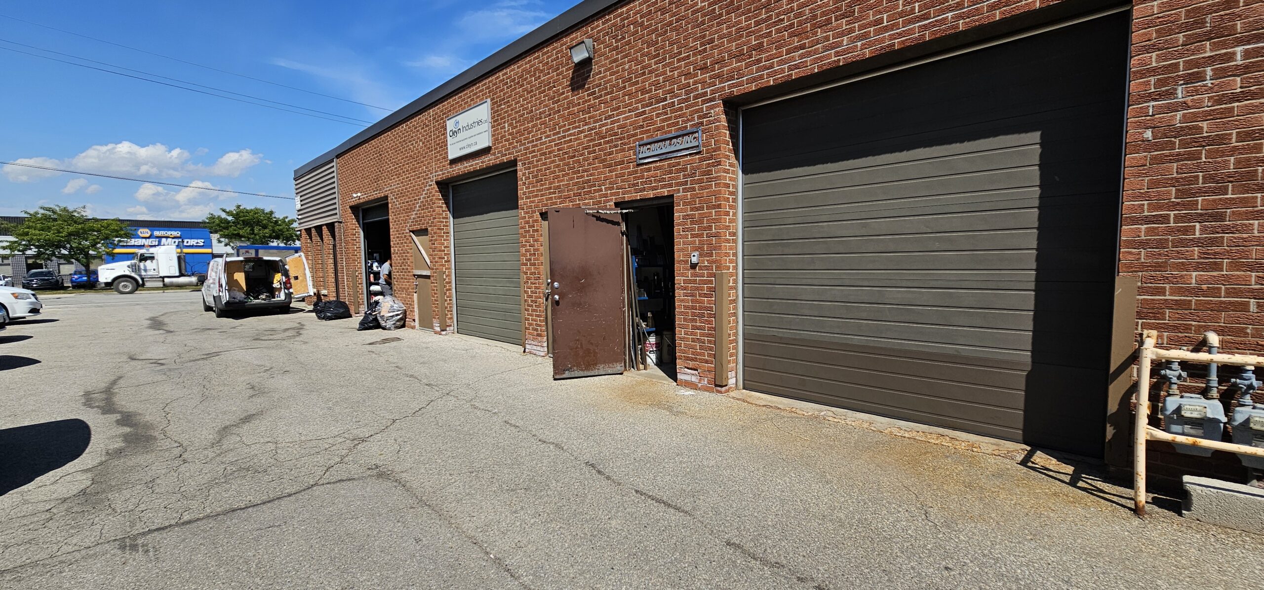 Brick building with two garage doors and clear blue sky