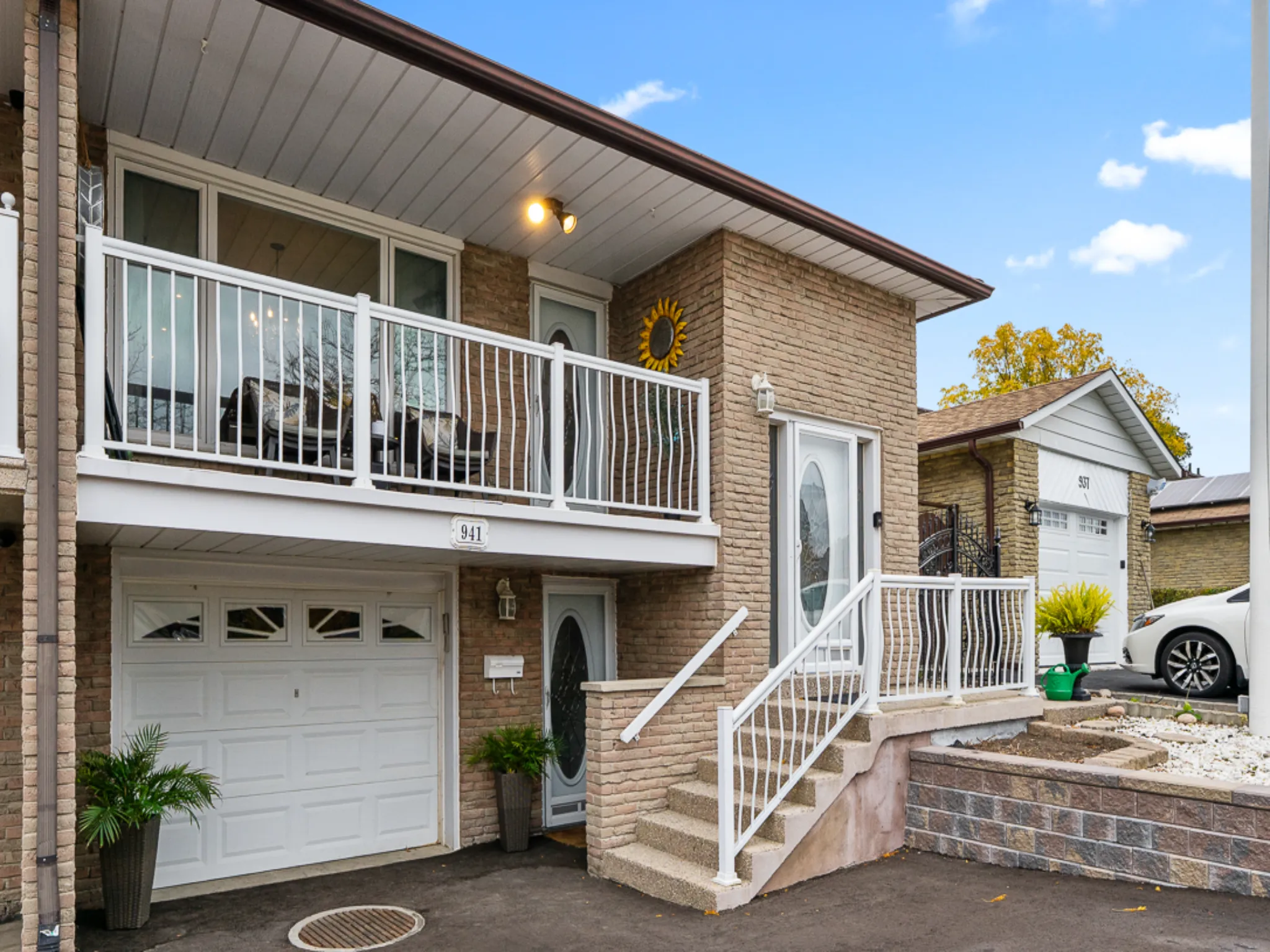 exterior of the home showing the white garage door, balcony and stairs leading to the front door
