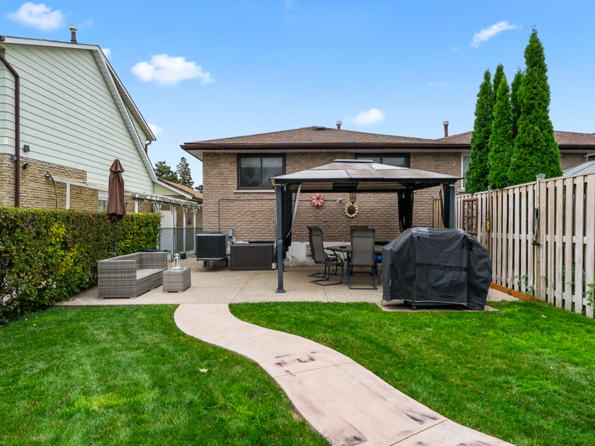 exterior backyard with green grass and fenced yard with gazebo