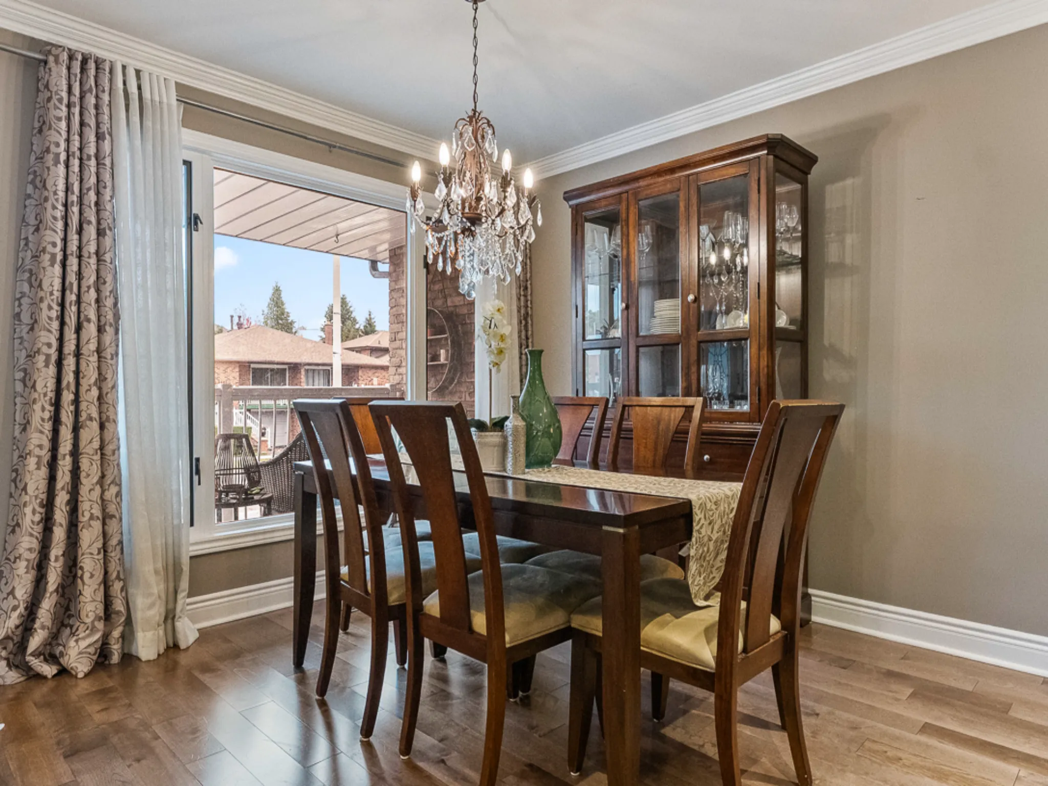 dining room with chandelier, crown molding and large window
