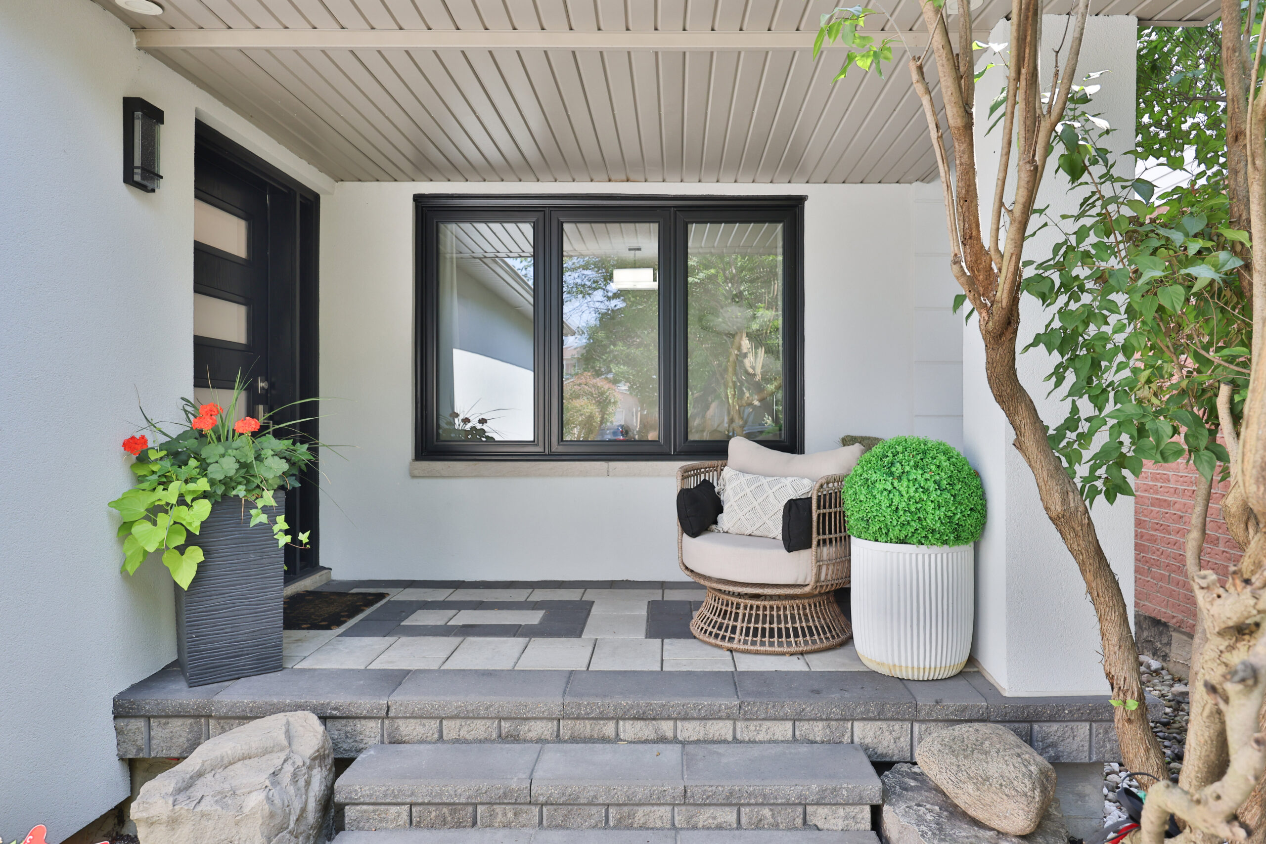 Modern front porch with potted plants and a cozy seating area