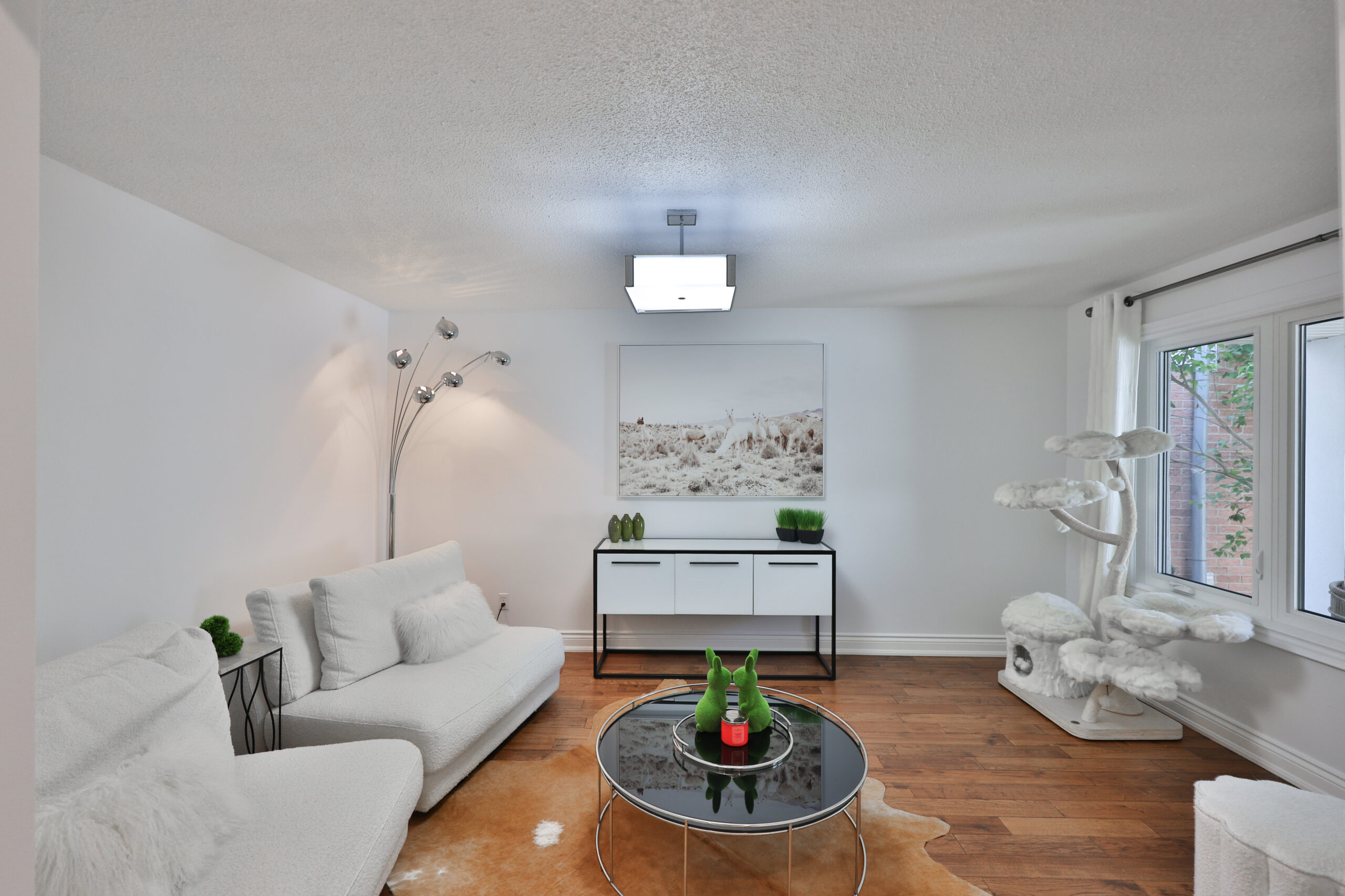 Modern living room with white furniture and wooden flooring