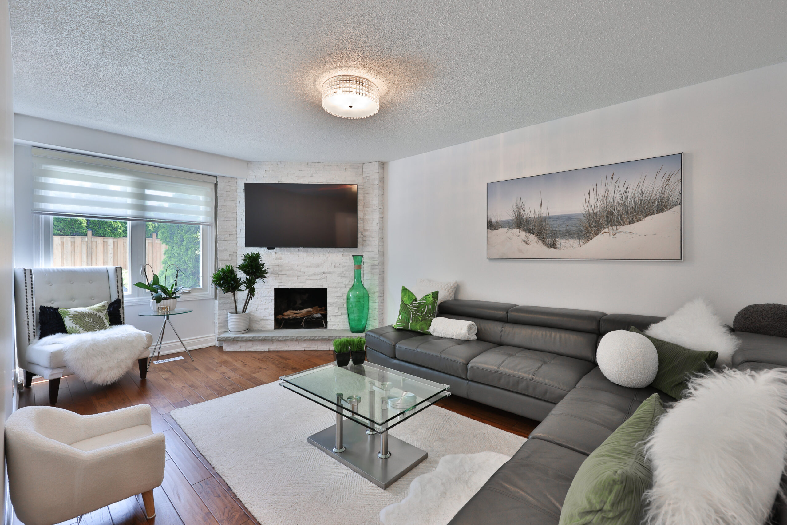 Modern living room with a gray sectional sofa and green accents