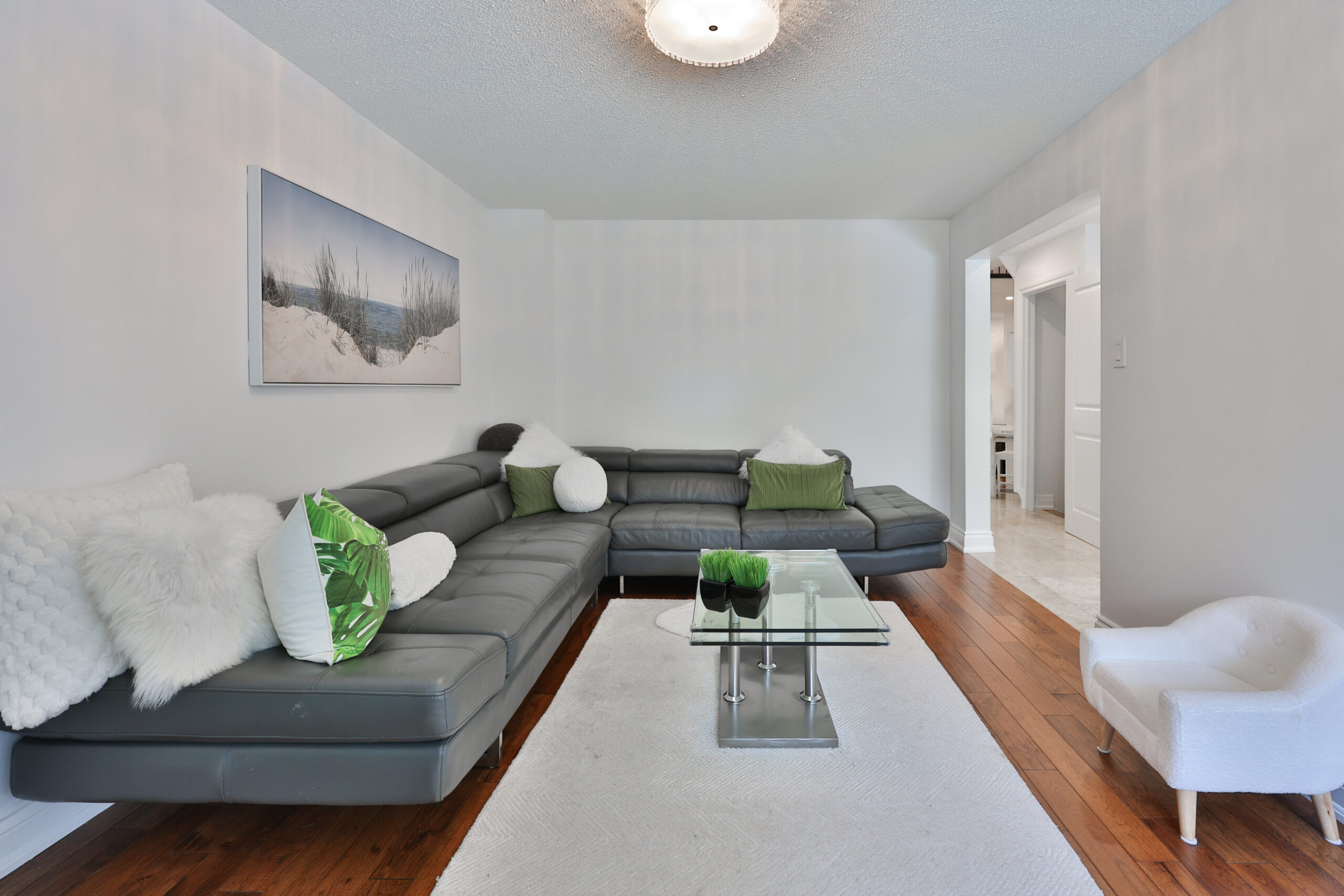 Modern living room with a dark sectional sofa and green accents