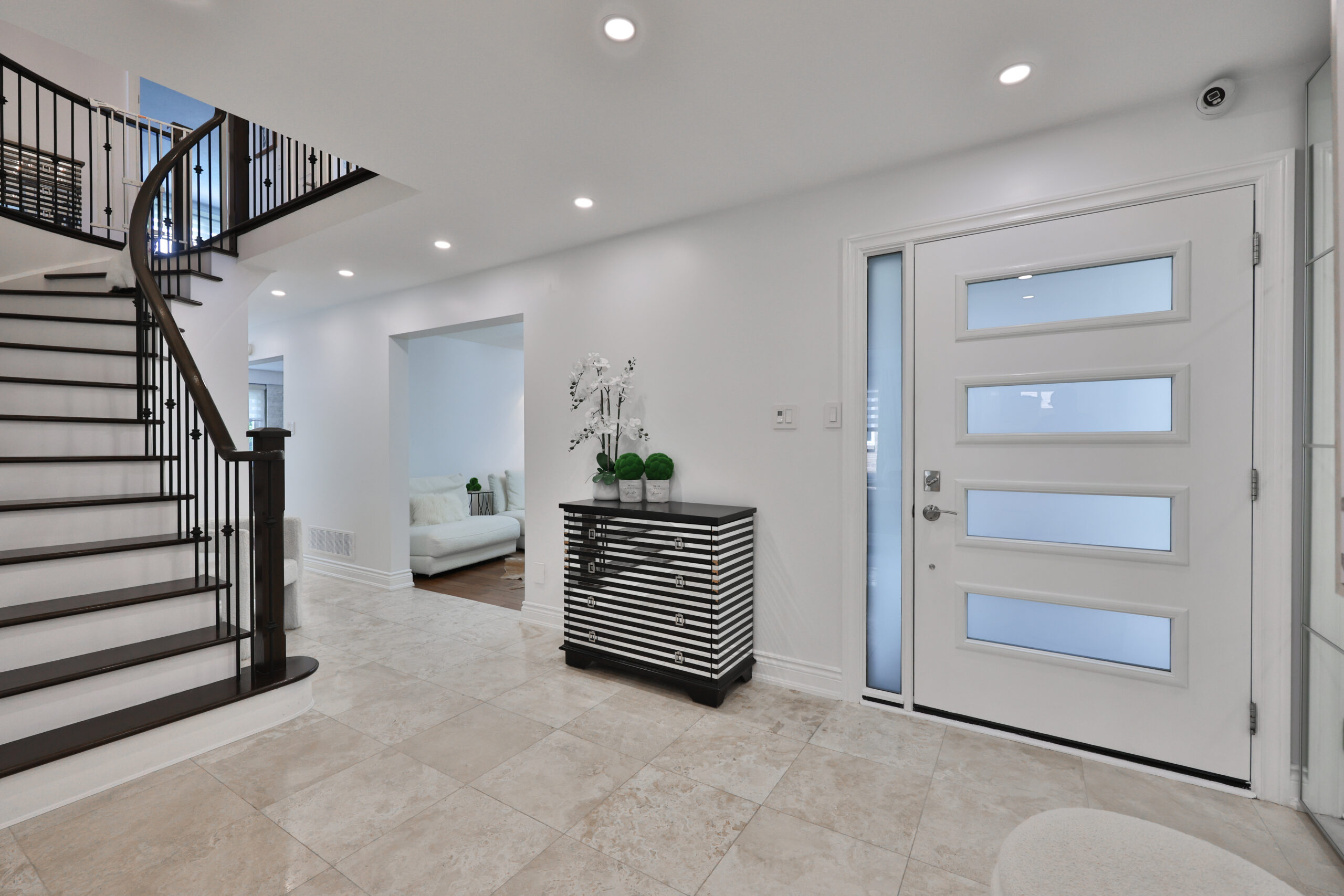 Modern entryway with a spiral staircase and sleek white door