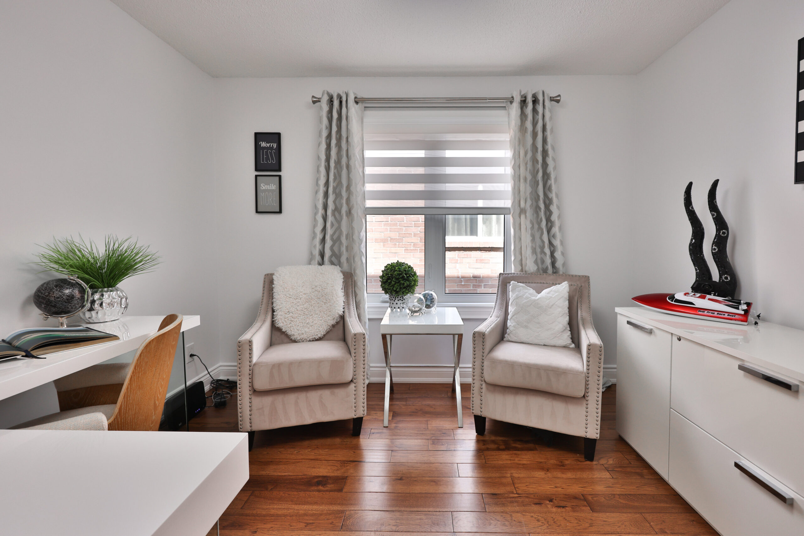 Cozy room with two chairs, a small table, and a window with curtains