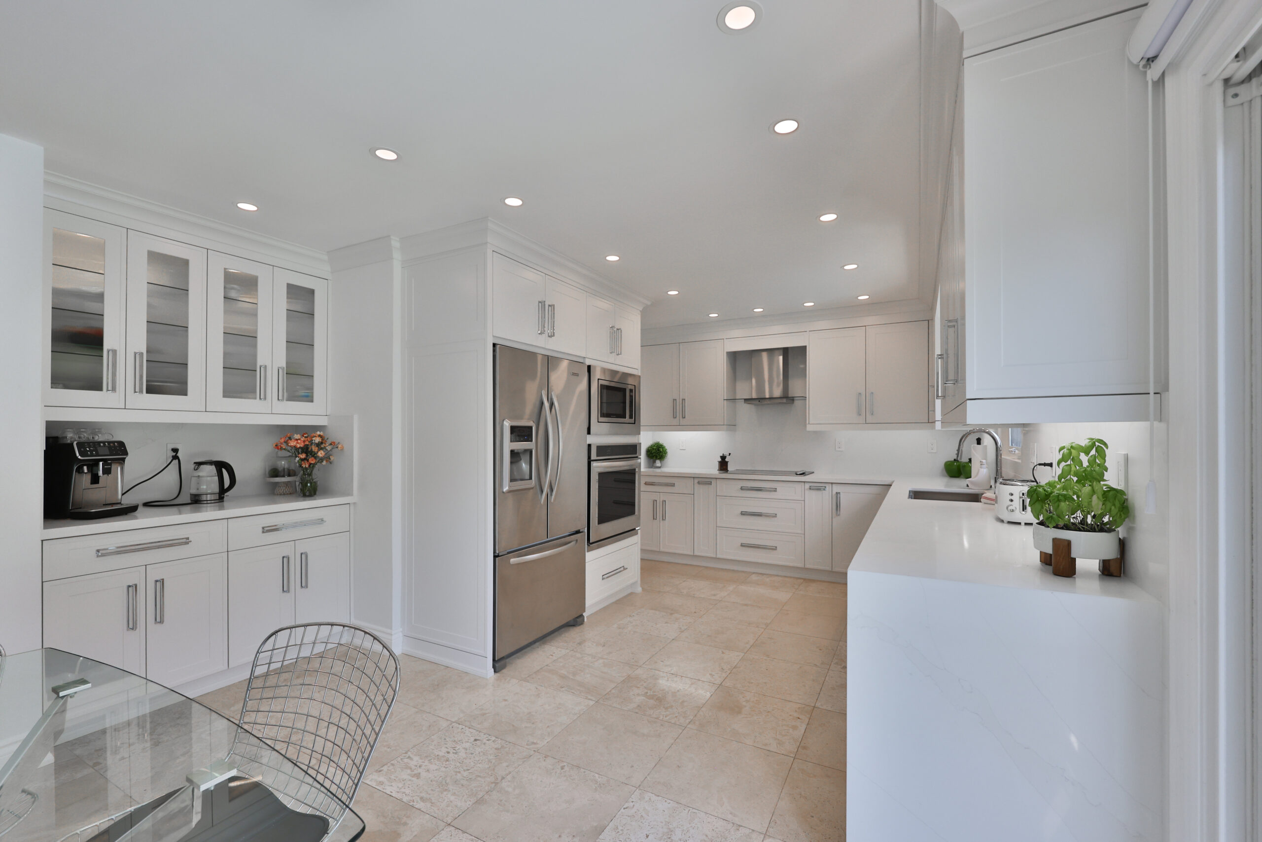 Modern kitchen with white cabinetry, stainless steel appliances, and natural light
