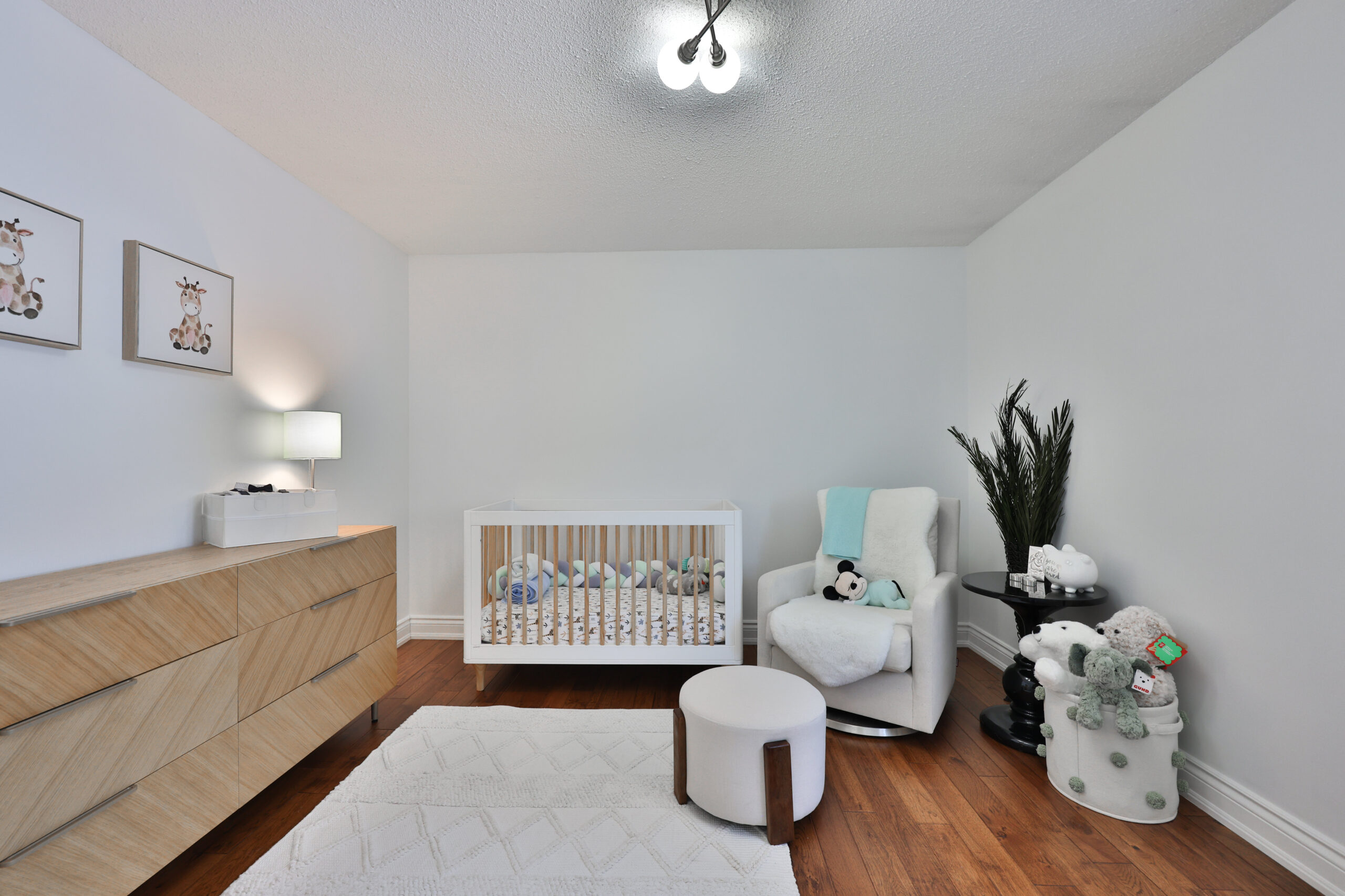Cozy nursery with a crib, rocking chair, and wooden dresser