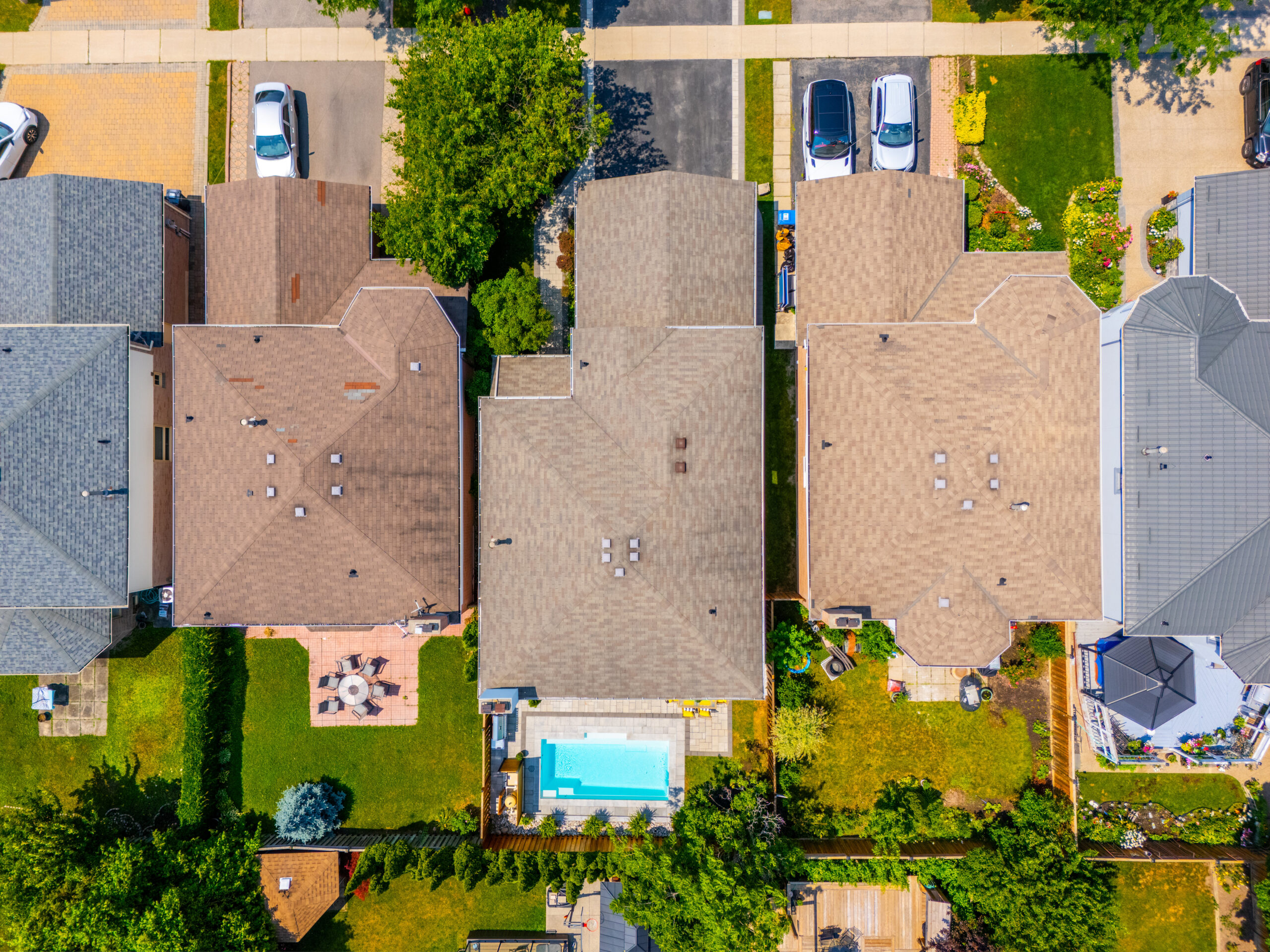 Aerial view of suburban homes with backyards and a swimming pool