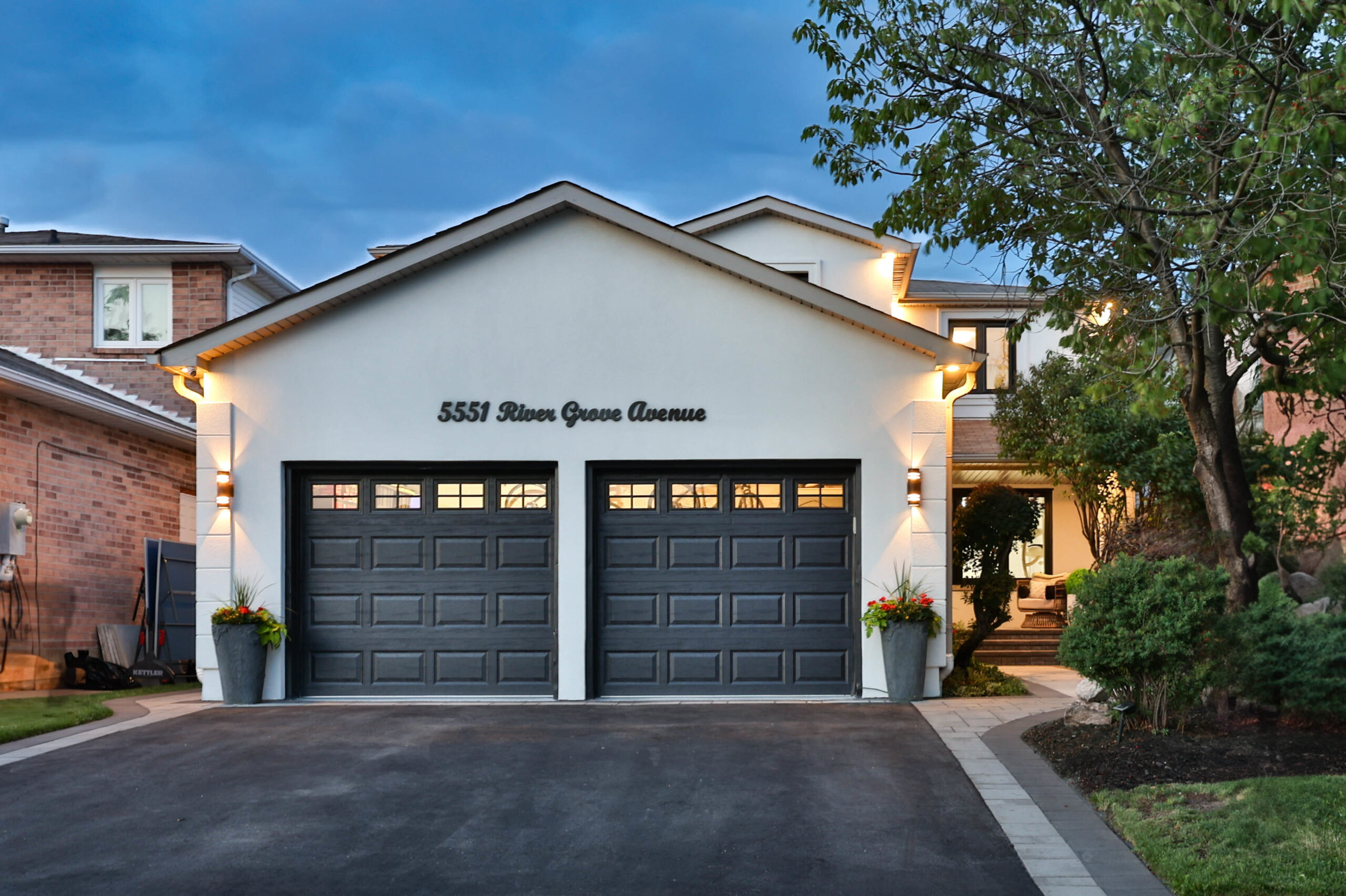 Modern home exterior with two garage doors and landscaped entrance.