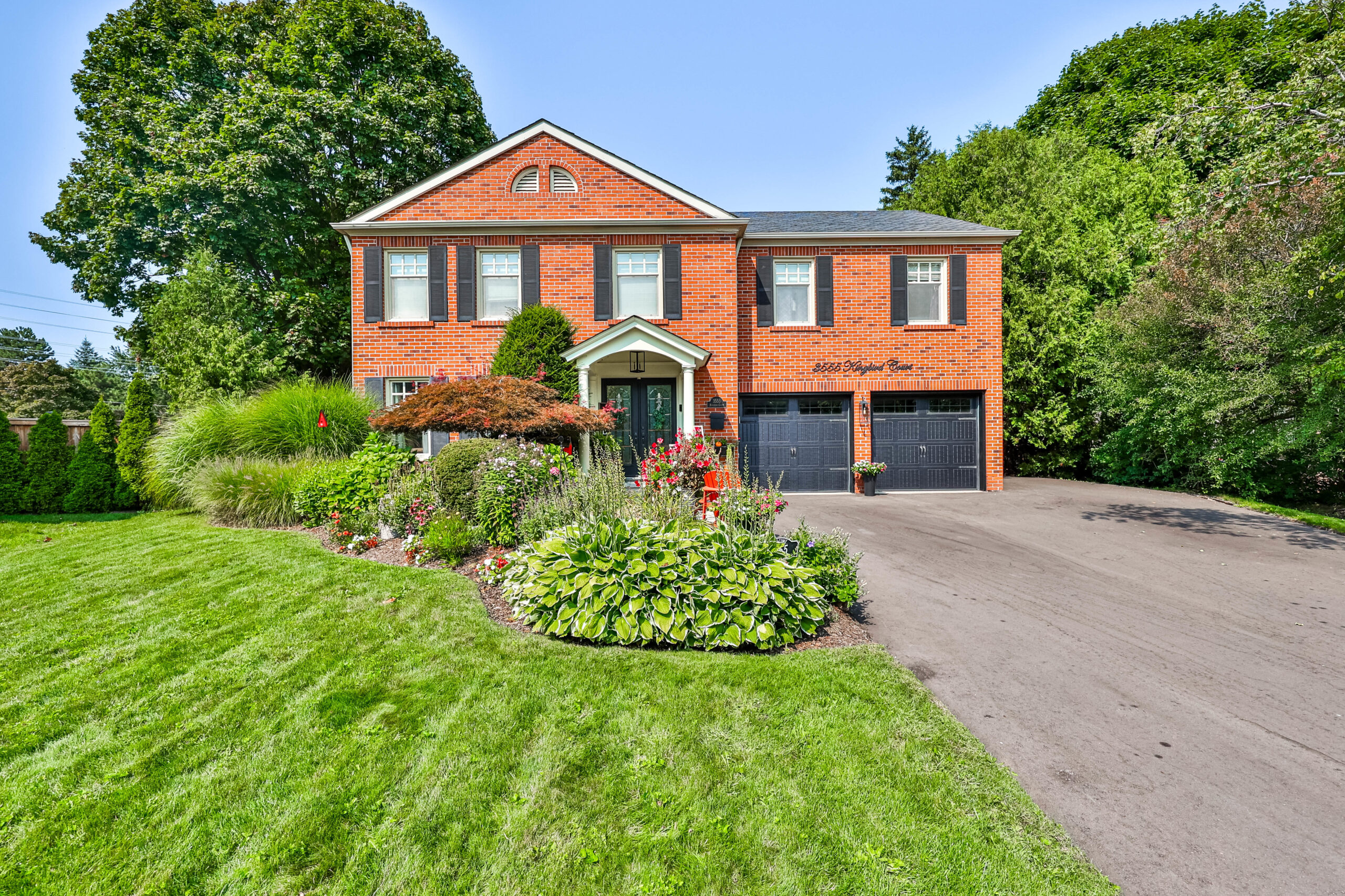 Two-story brick house with landscaped garden and driveway in Mississauga