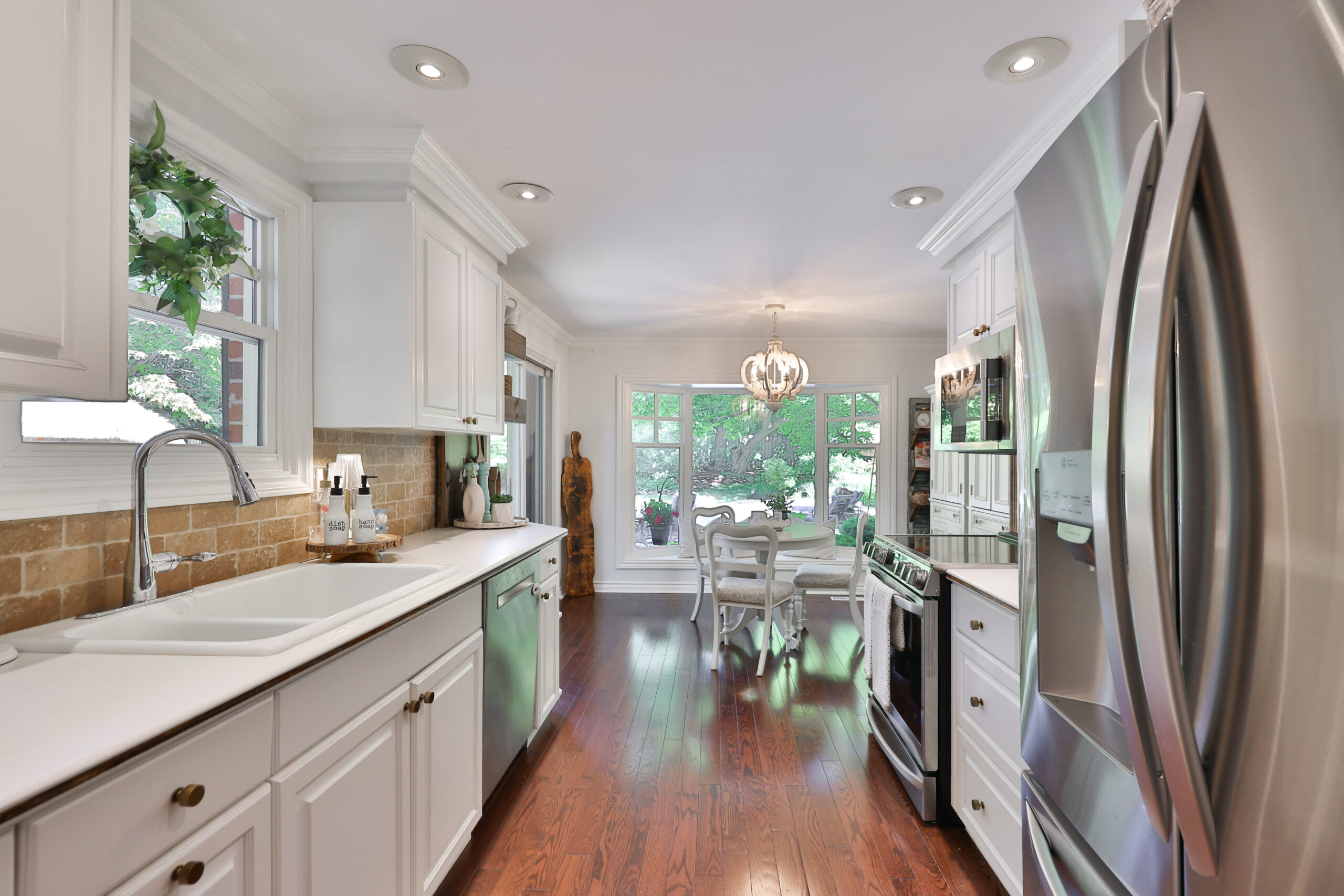 galley kitchen with stainless steel appliance leading to breakfast area
