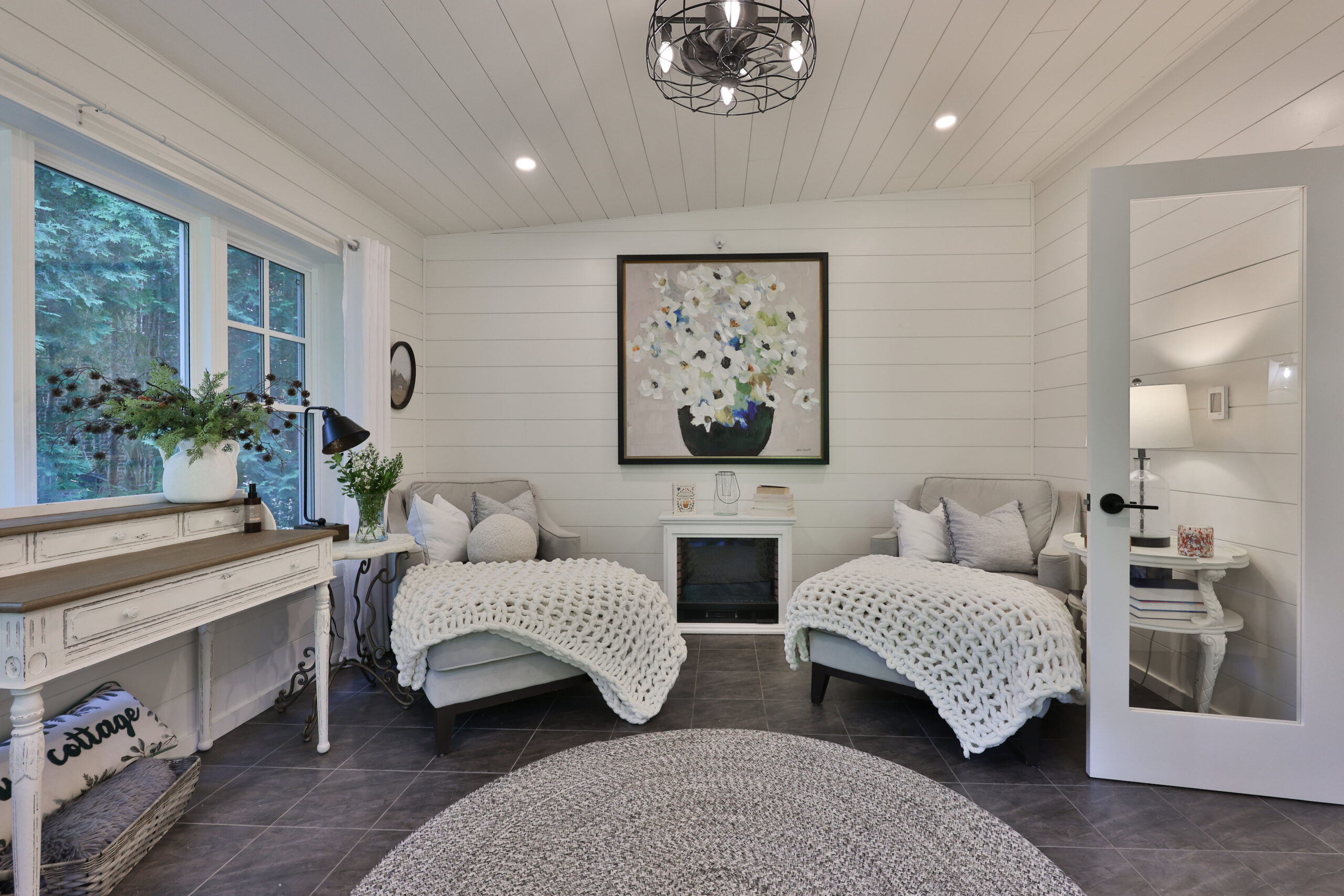 Cozy bedroom with two twin beds, floral artwork, and a decorative table