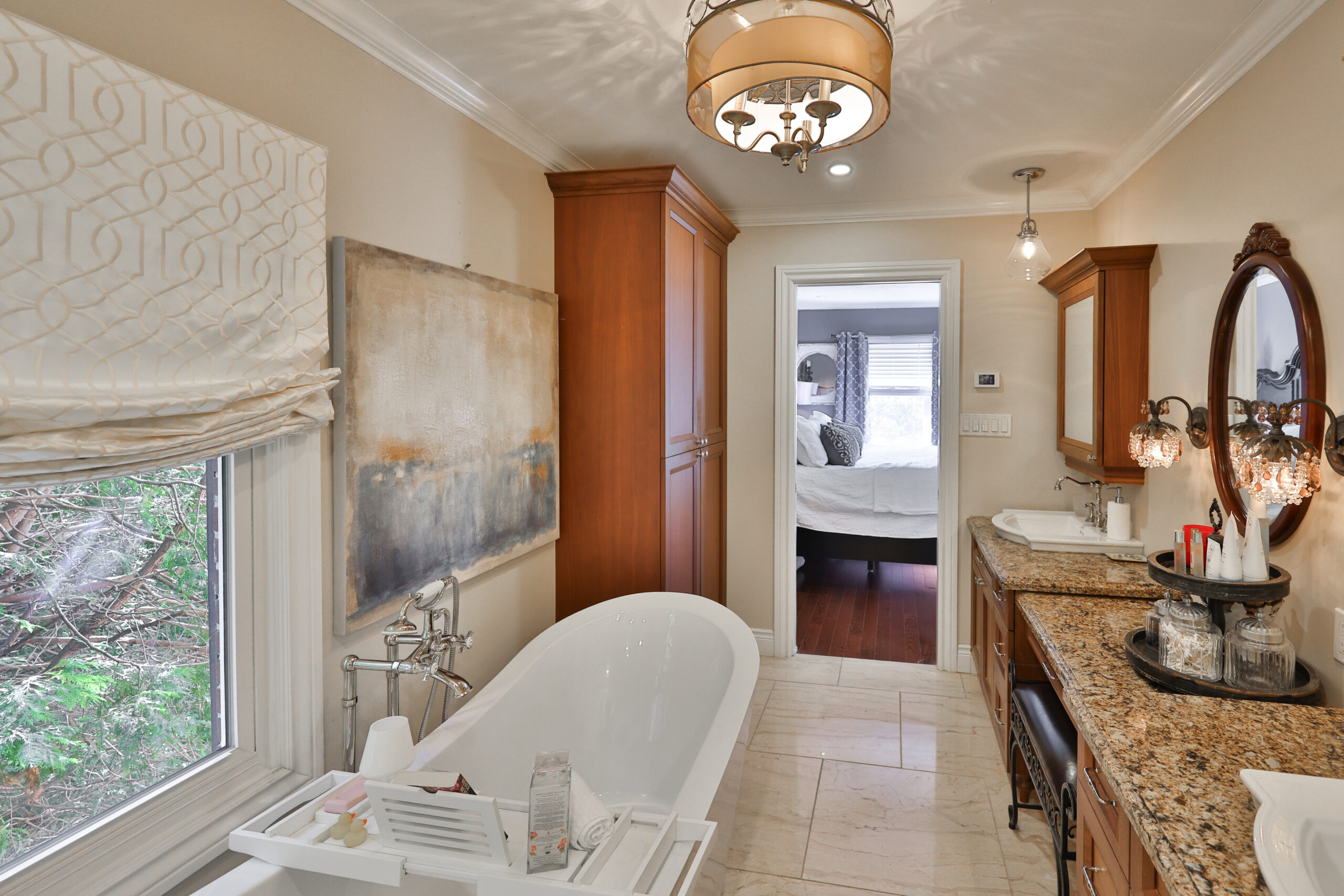Elegant bathroom featuring a freestanding tub, granite countertop, and natural light